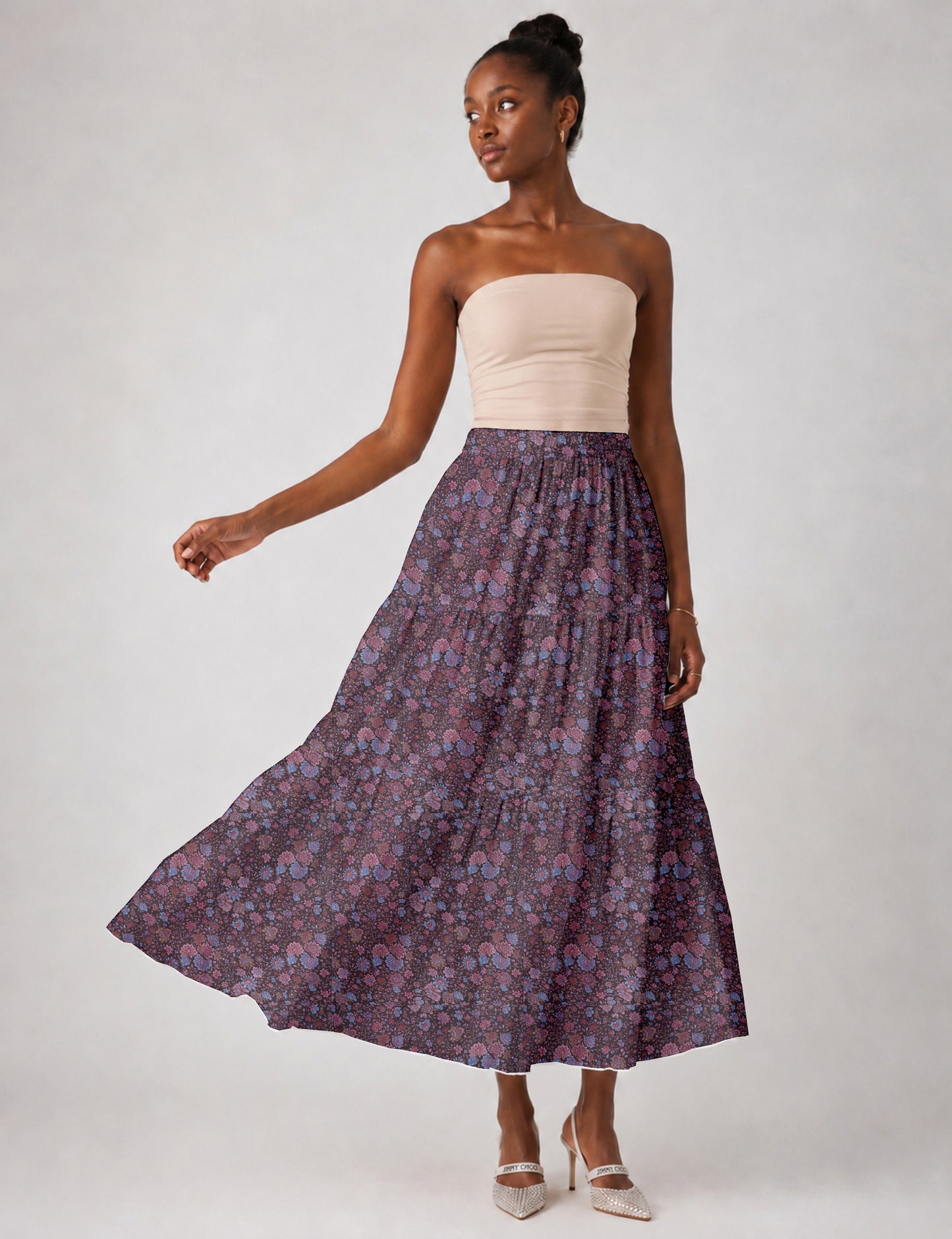 Woman wearing a yellow midi tiered skirt with a small geometric pattern, shown from the back, paired with beige top and
