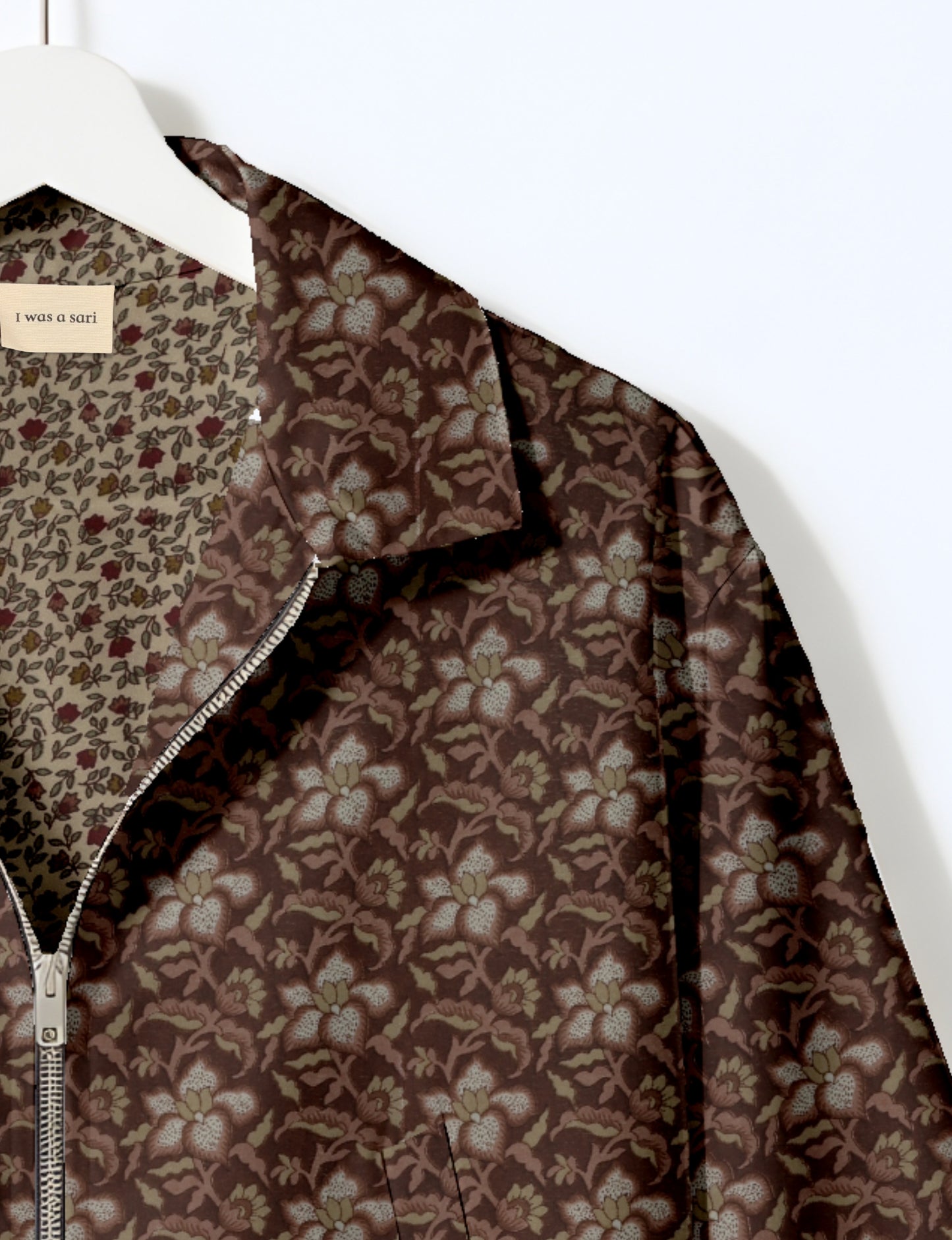 Women's cropped bomber jacket with twin metallic front zippers, welt pockets, elasticated hem and cuffs, and contrast sari print lining.