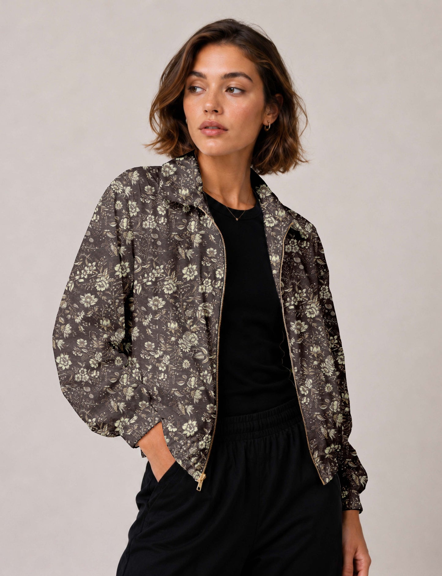 Woman wearing a yellow floral bomber jacket with front zipper, elastic cuffs, and side pockets, shown from front view