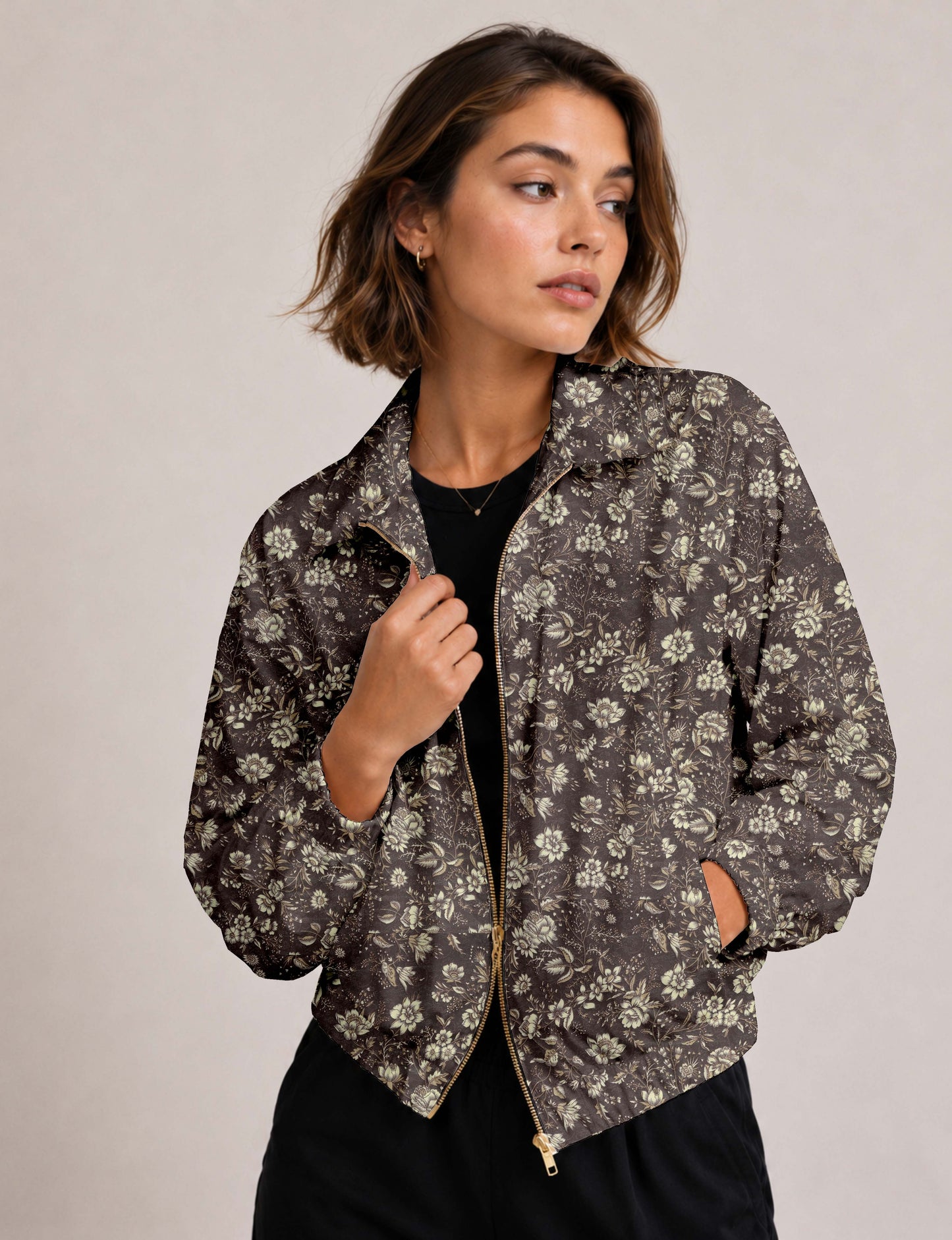 Brown floral bomber jacket with front zipper, elastic cuffs and hem, hanging on white hanger, red floral inner lining visible