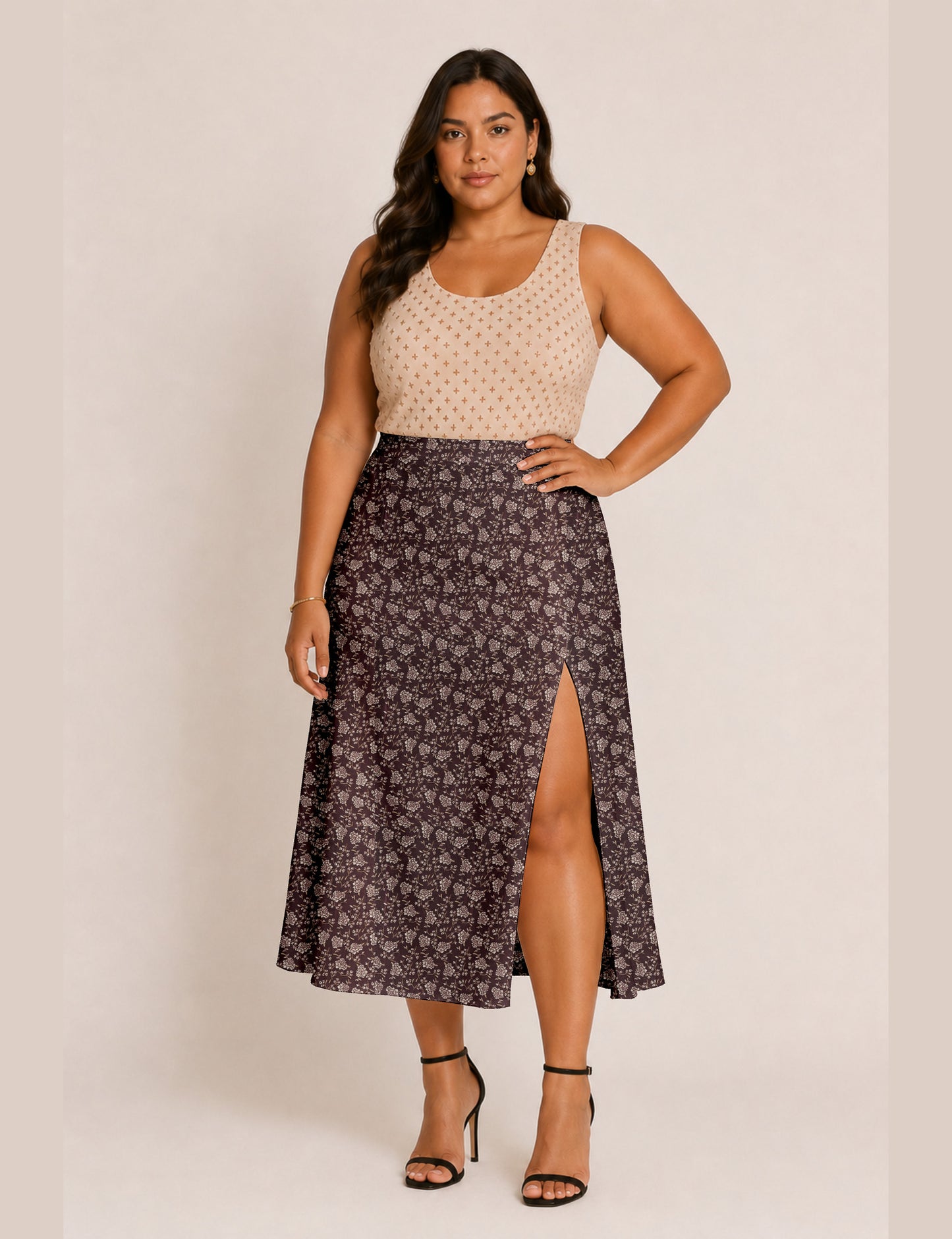 Woman wearing a yellow and black micro patterned A-line skirt with front slit, paired with beige sleeveless top and black