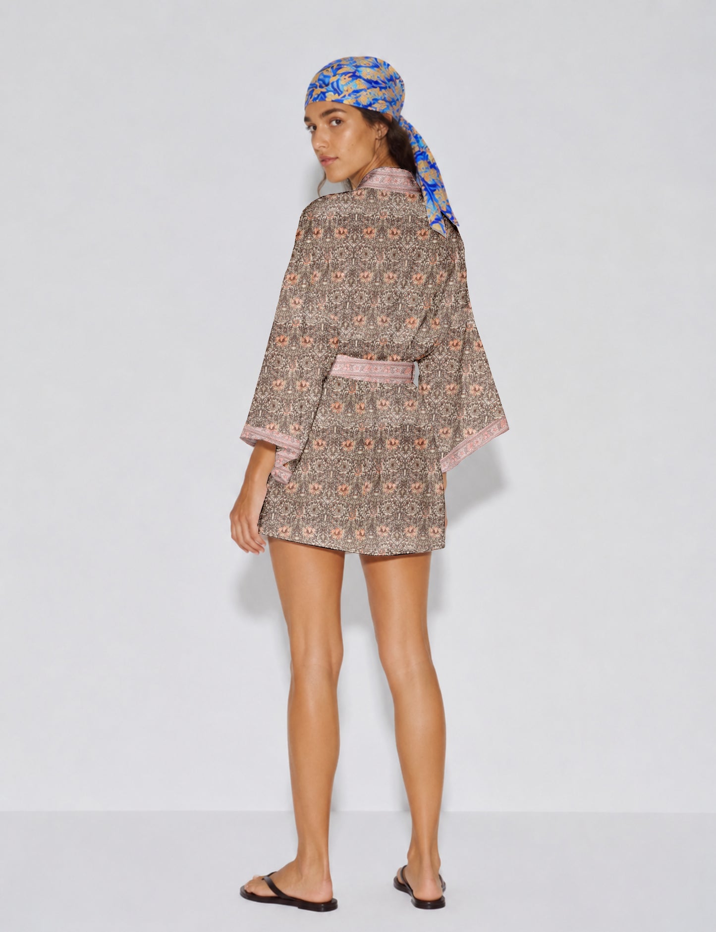 Short kimono robe with wrap front, V-neckline, wide sleeves, waist tie, and concealed skort detail.