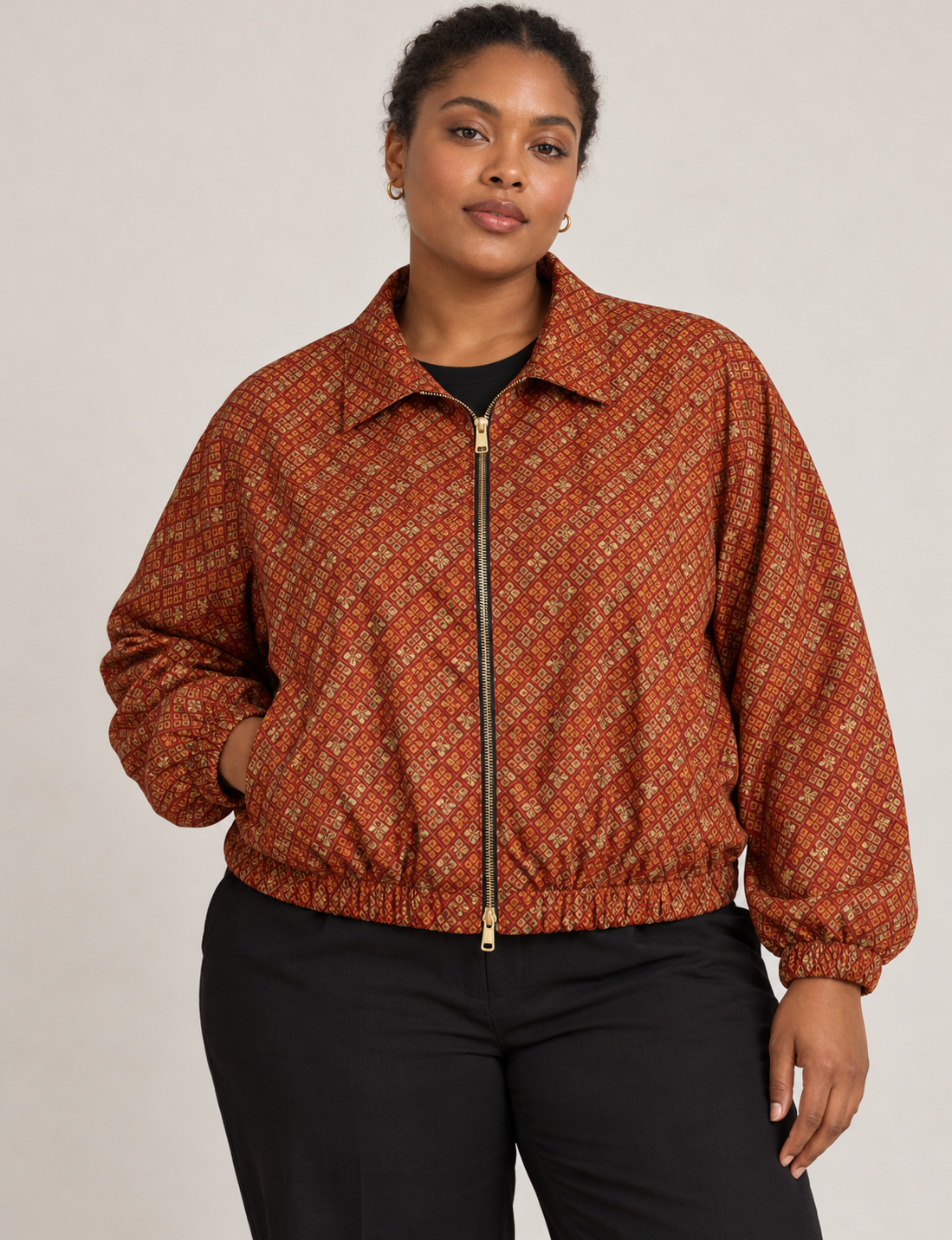 Woman wearing a yellow floral bomber jacket with front zipper, elastic cuffs, and side pockets, shown from front view
