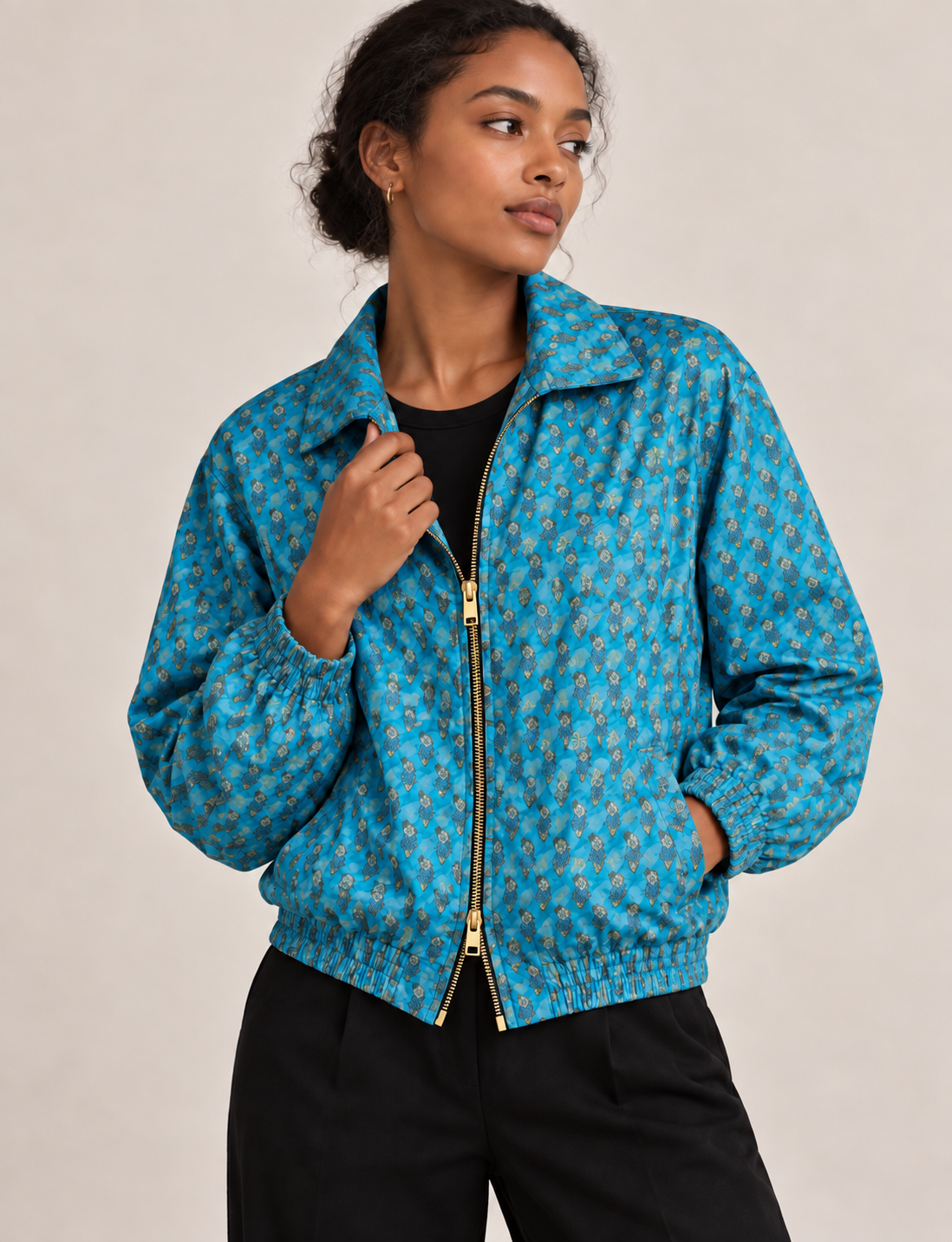 Woman wearing a yellow floral bomber jacket with front zipper, elastic cuffs, and side pockets, shown from front view