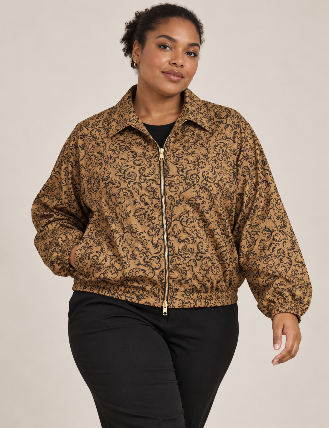 Woman wearing a yellow floral bomber jacket with front zipper, elastic cuffs, and side pockets, shown from front view