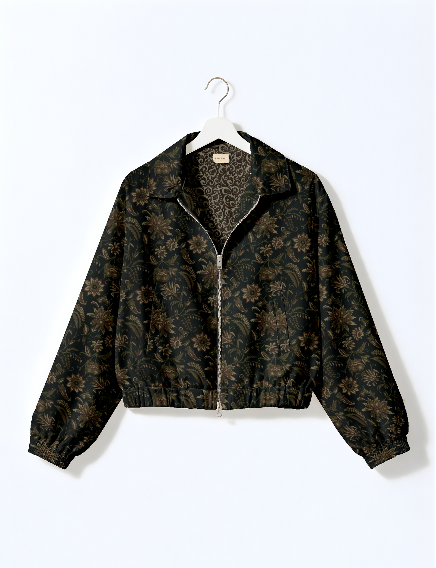 Women's cropped bomber jacket with twin metallic front zippers, welt pockets, elasticated hem and cuffs, and contrast sari print lining.