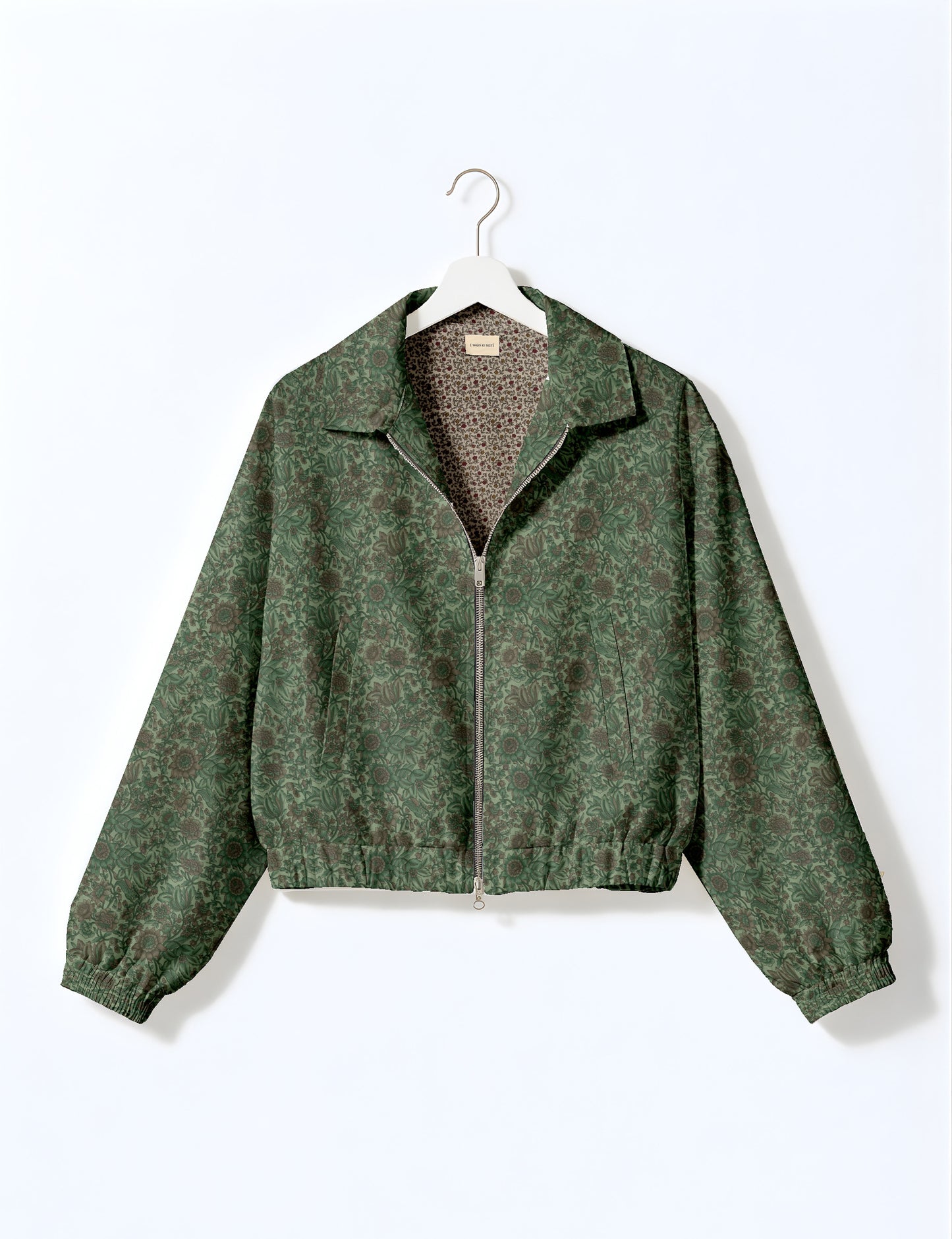Brown floral bomber jacket with front zipper, elastic cuffs and hem, hanging on white hanger, red floral inner lining visible