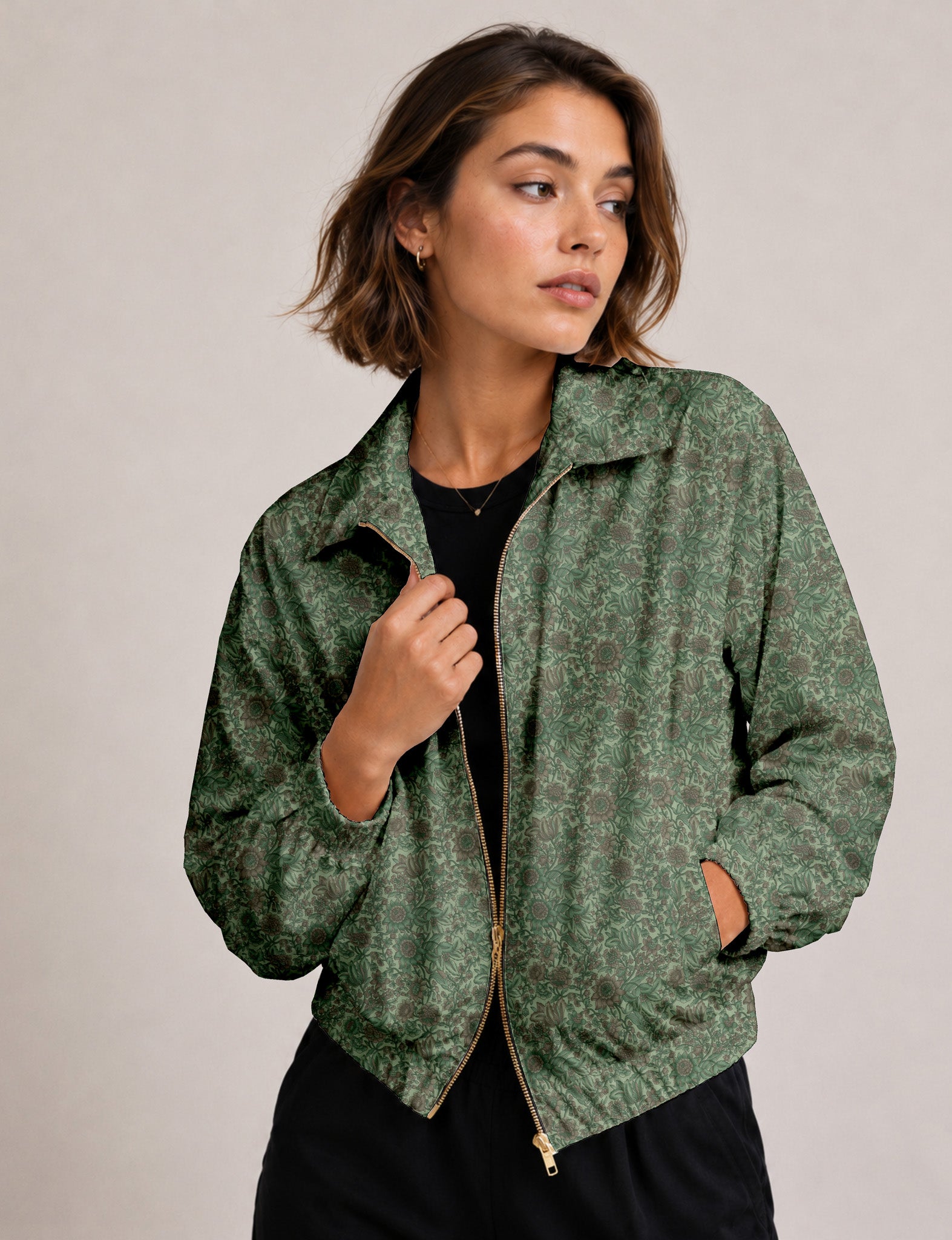 Woman wearing a yellow floral bomber jacket with front zipper, elastic cuffs, and side pockets, shown from front view