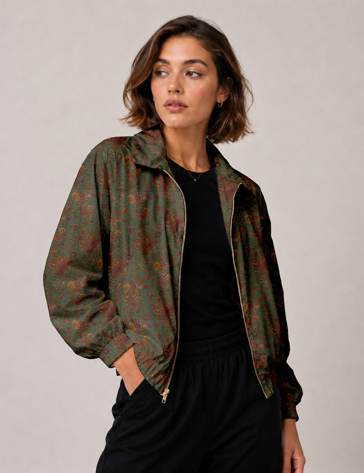 Woman wearing a yellow floral bomber jacket with front zipper, elastic cuffs, and side pockets, shown from front view