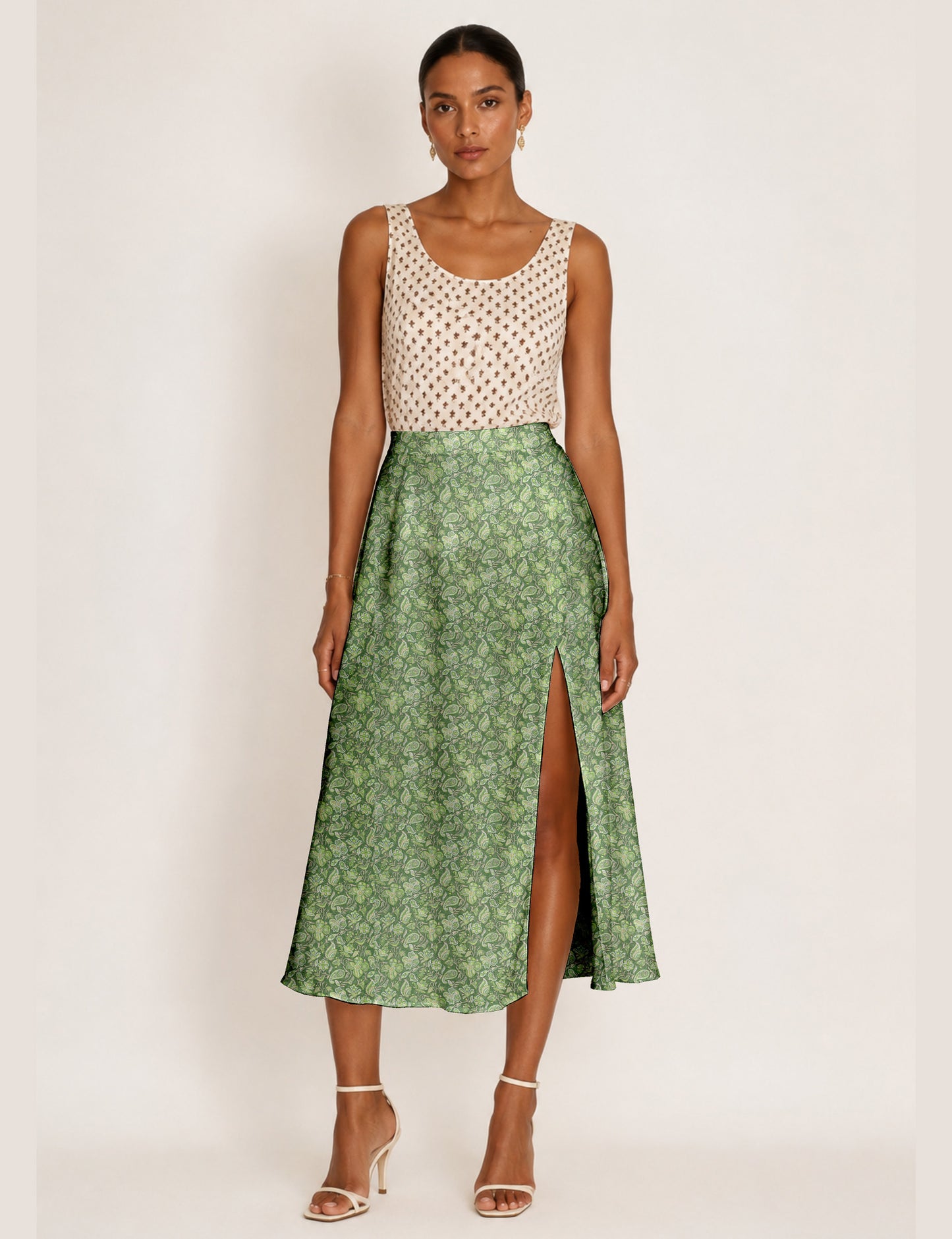 Woman wearing a yellow and black micro patterned A-line skirt with front slit, paired with beige sleeveless top and black