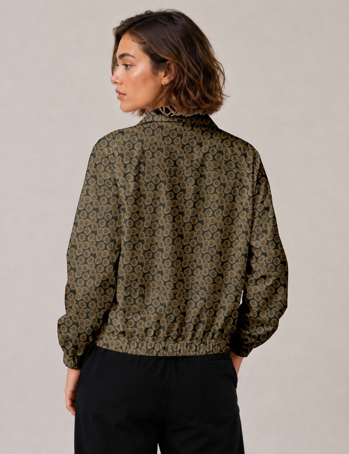 Brown floral bomber jacket with front zipper, elastic cuffs and hem, hanging on white hanger, red floral inner lining visible