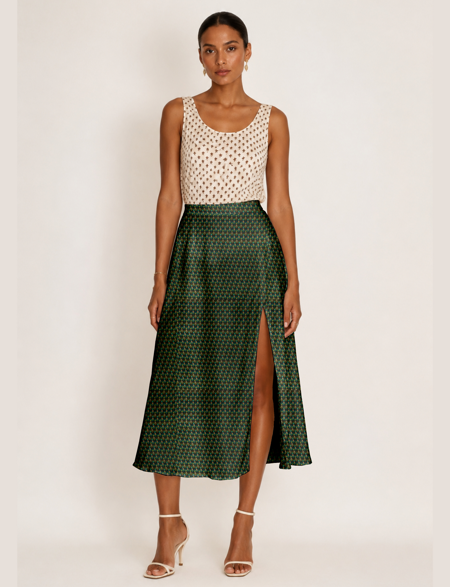Woman wearing a yellow and black micro patterned A-line skirt with front slit, paired with beige sleeveless top and black
