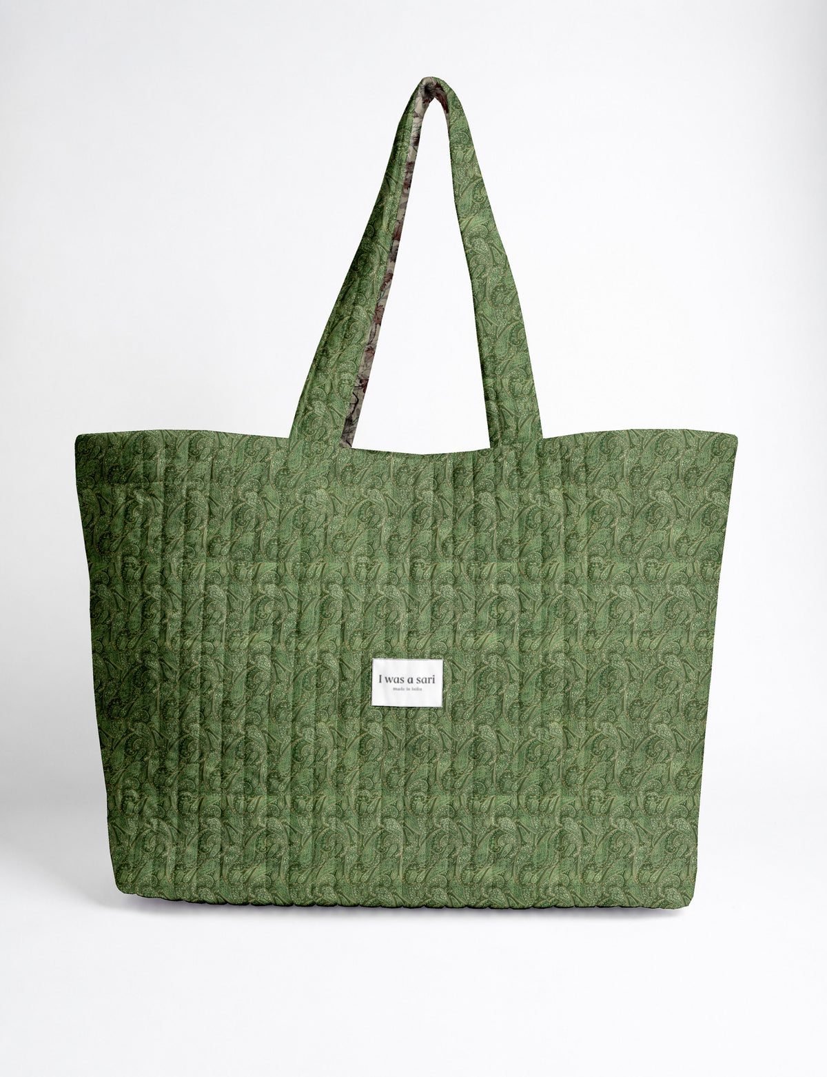 Quilted yellow tropical patterned beach bag with long handles and white label reading "I was a sari" front view