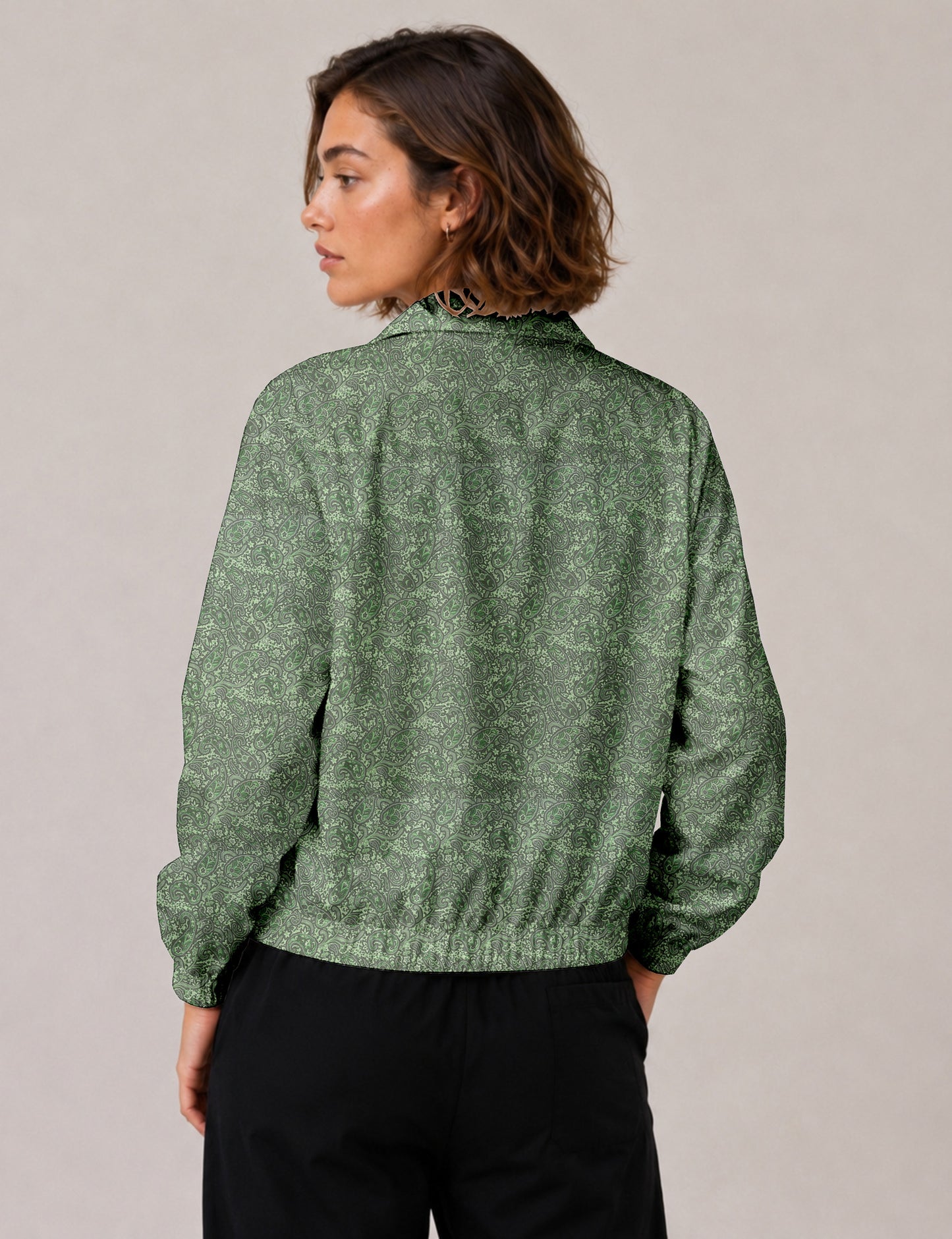 Woman wearing a yellow floral bomber jacket with front zipper, elastic cuffs, and side pockets, shown from front view