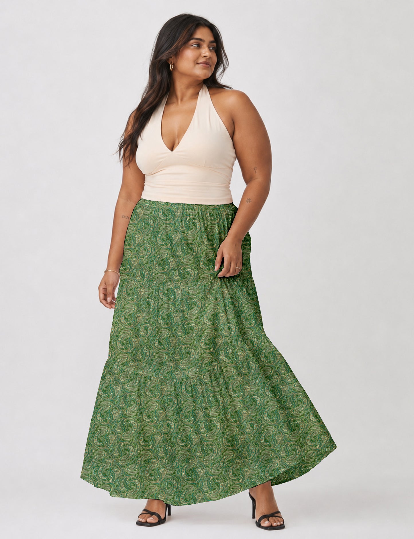 Woman wearing a yellow midi tiered skirt with a small geometric pattern, shown from the back, paired with beige top and