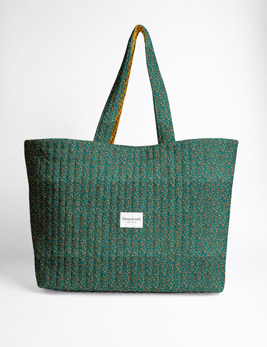 Quilted yellow tropical patterned beach bag with long handles and white label reading "I was a sari" front view