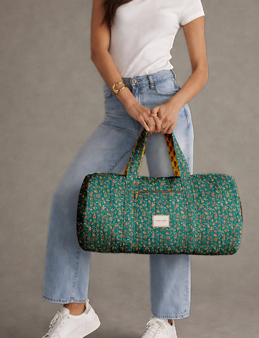 Brown paisley quilted bowling bag with dual handles, front zipper pocket, and "I was a sari" label on front side