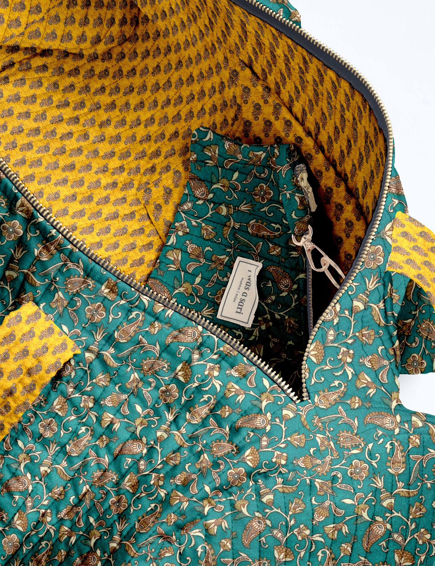 Brown paisley quilted bowling bag with front zipper pocket, held by person wearing white shirt and light blue jeans
