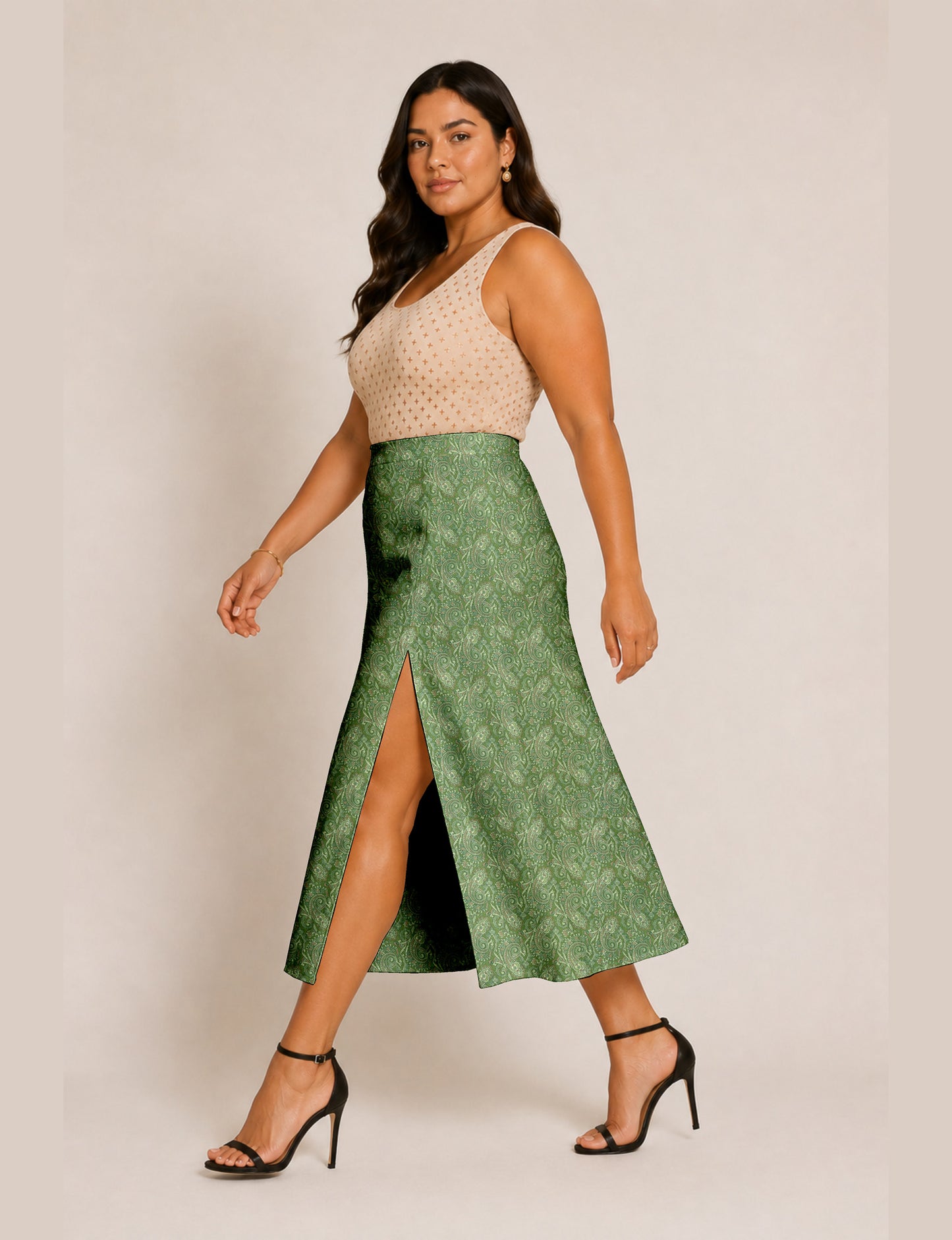 Woman wearing a yellow and black micro patterned A-line skirt with front slit, paired with beige sleeveless top and black