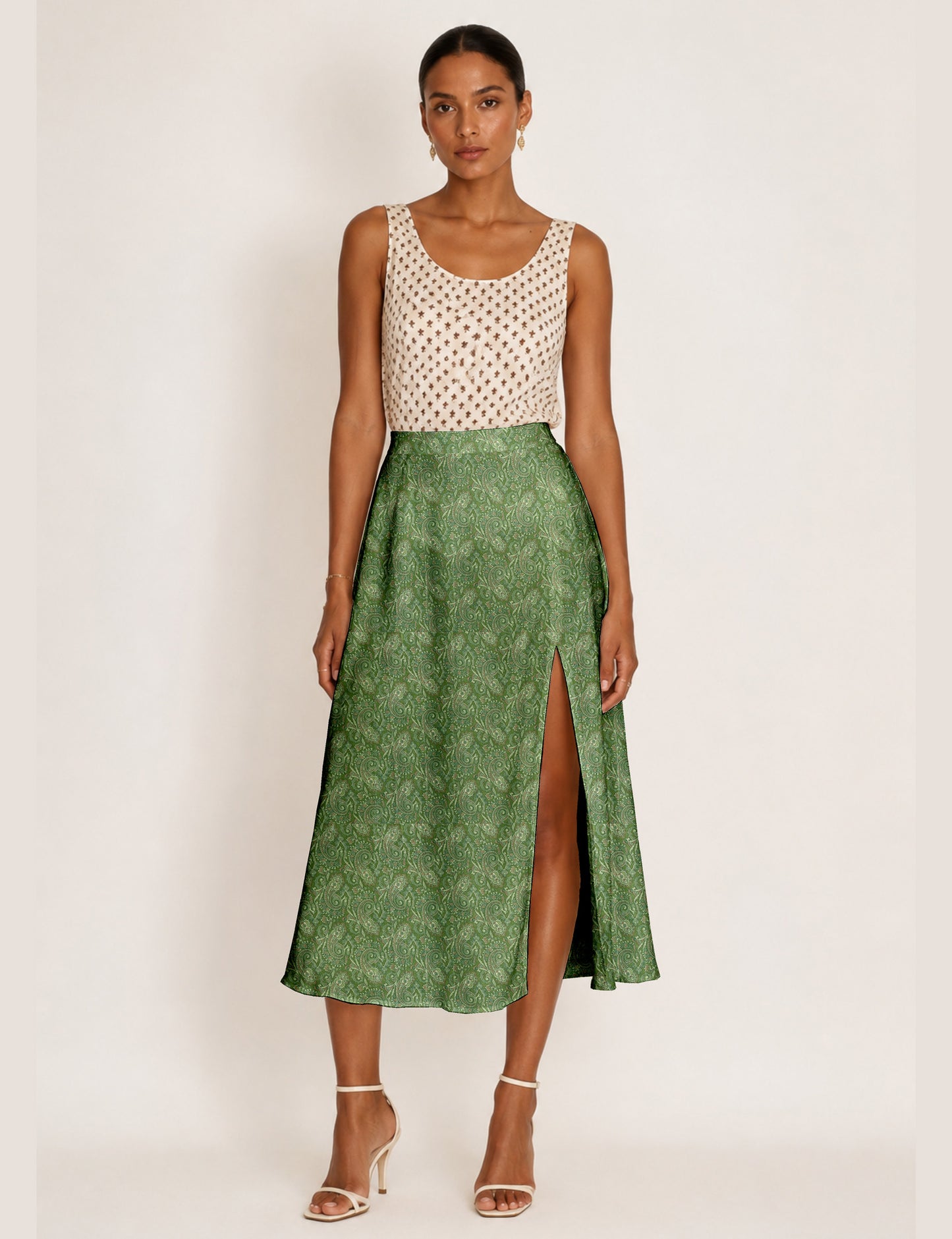 Woman wearing a yellow and black micro patterned A-line skirt with front slit, paired with beige sleeveless top and black