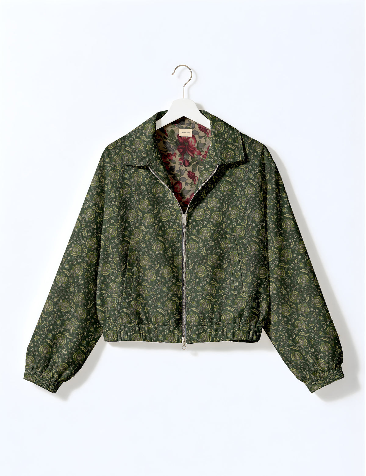 Brown floral bomber jacket with front zipper, elastic cuffs and hem, hanging on white hanger, red floral inner lining visible