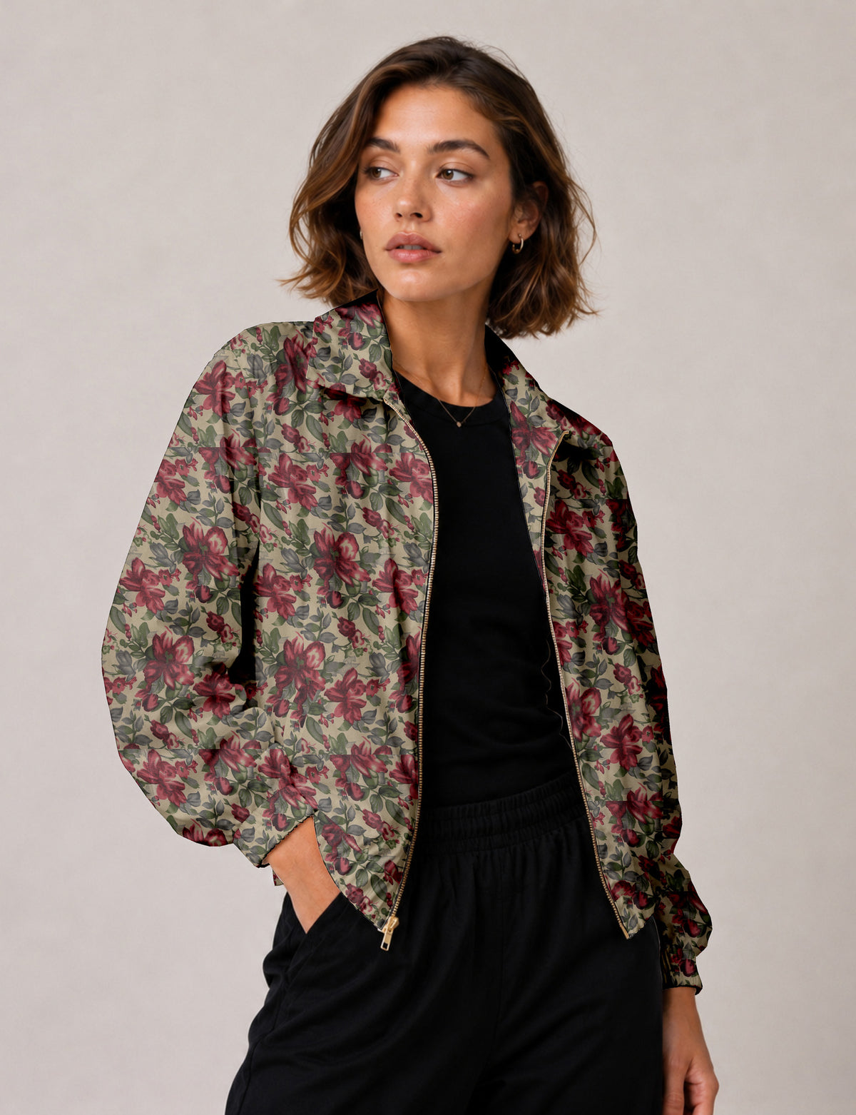 Woman wearing a yellow floral bomber jacket with front zipper, elastic cuffs, and side pockets, shown from front view
