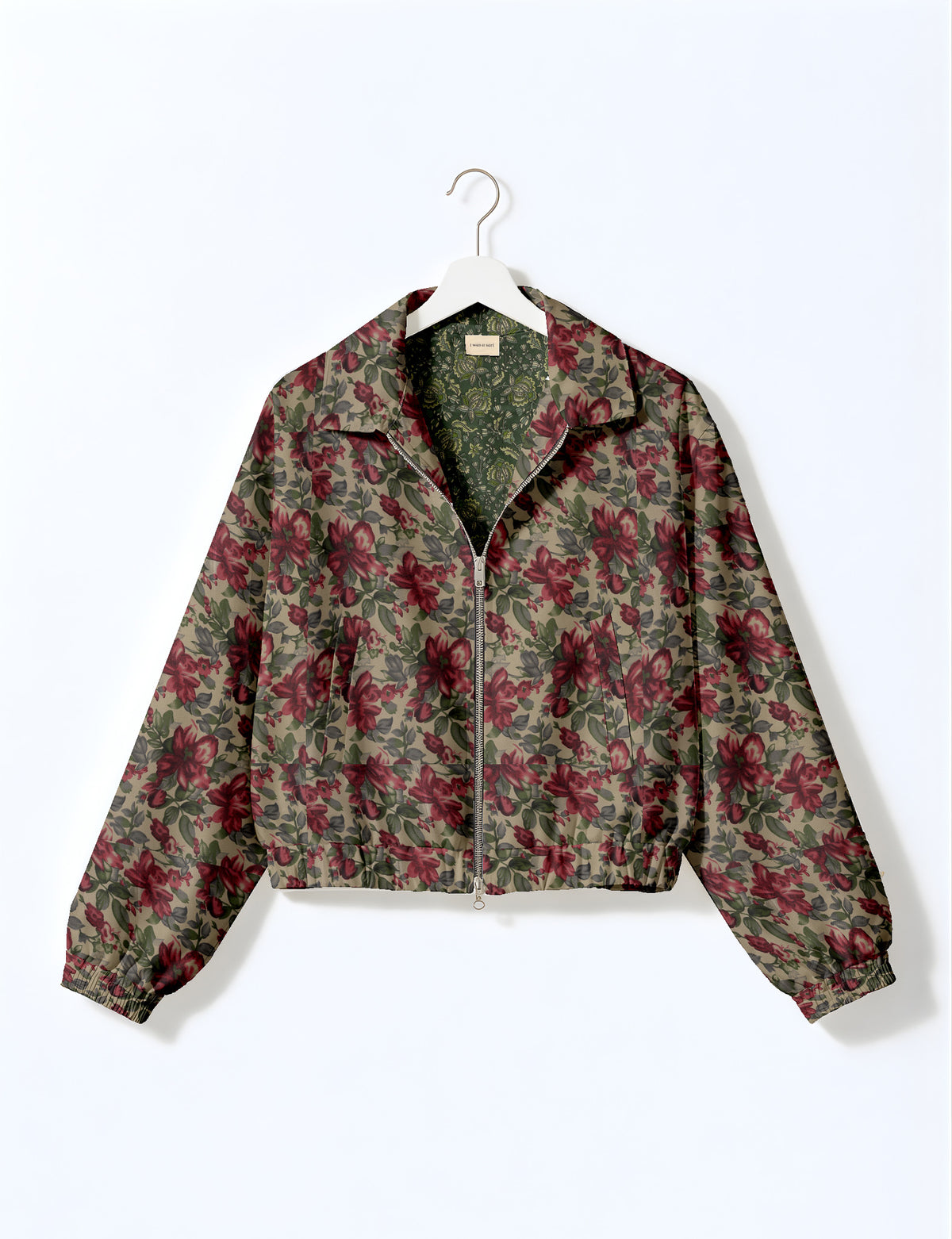 Brown floral bomber jacket with front zipper, elastic cuffs and hem, hanging on white hanger, red floral inner lining visible