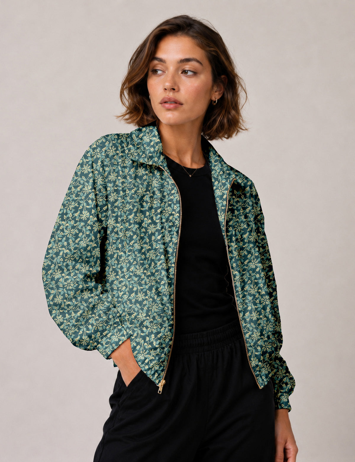 Woman wearing a yellow floral bomber jacket with front zipper, elastic cuffs, and side pockets, shown from front view