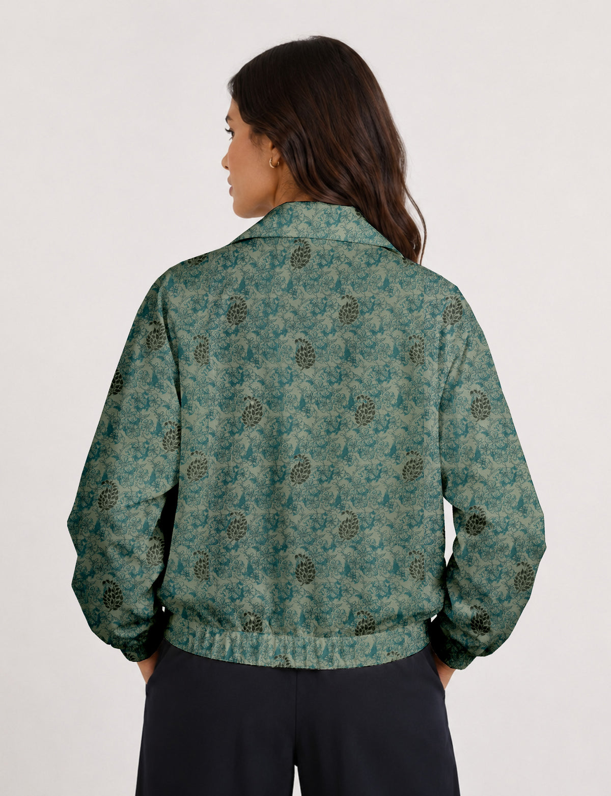 Brown floral bomber jacket with front zipper, elastic cuffs and hem, hanging on white hanger, red floral inner lining visible