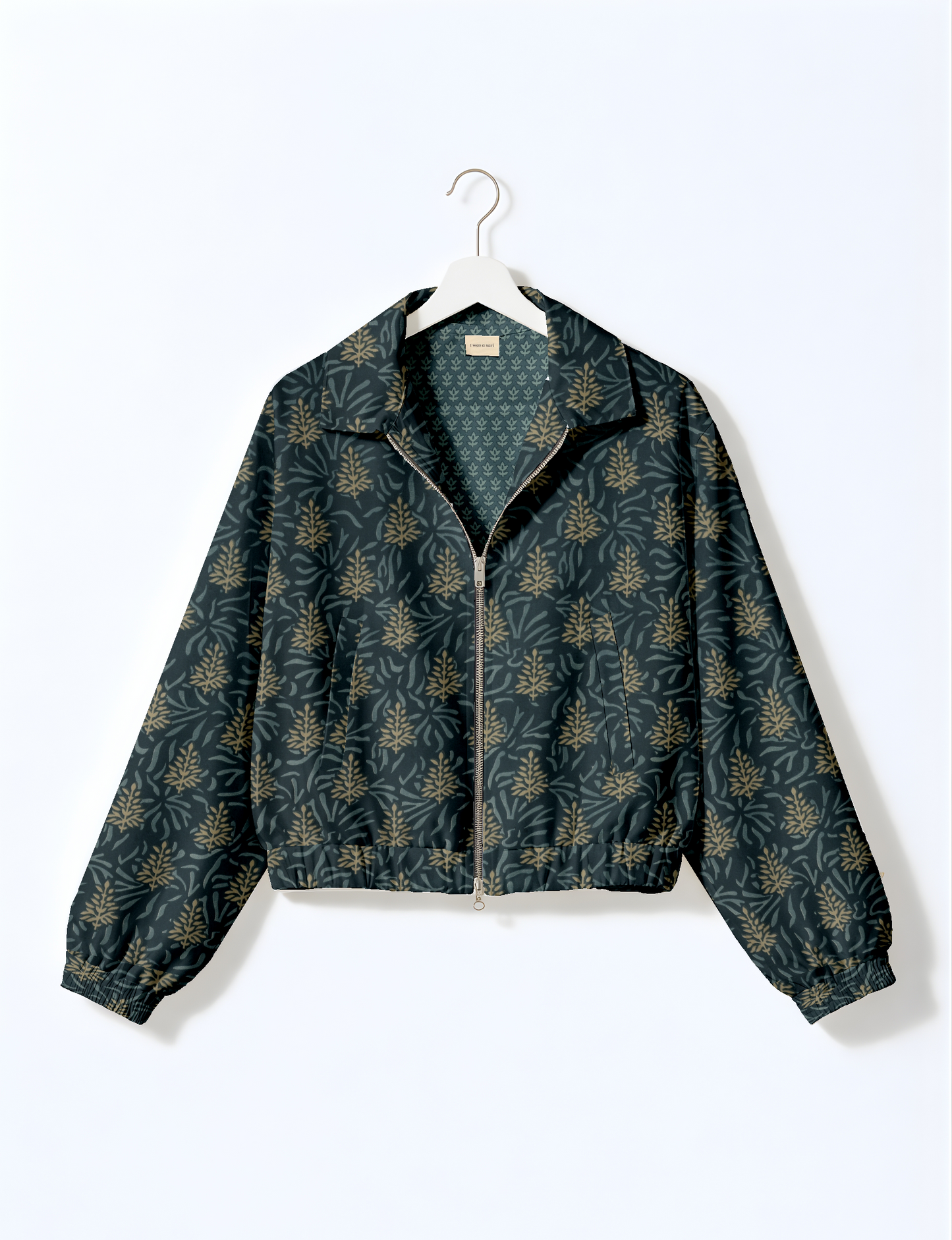 Women's cropped bomber jacket with twin metallic front zippers, welt pockets, elasticated hem and cuffs, and contrast sari print lining.