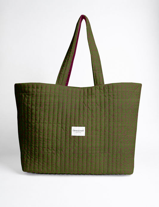 Quilted yellow tropical patterned beach bag with long handles and white label reading "I was a sari" front view