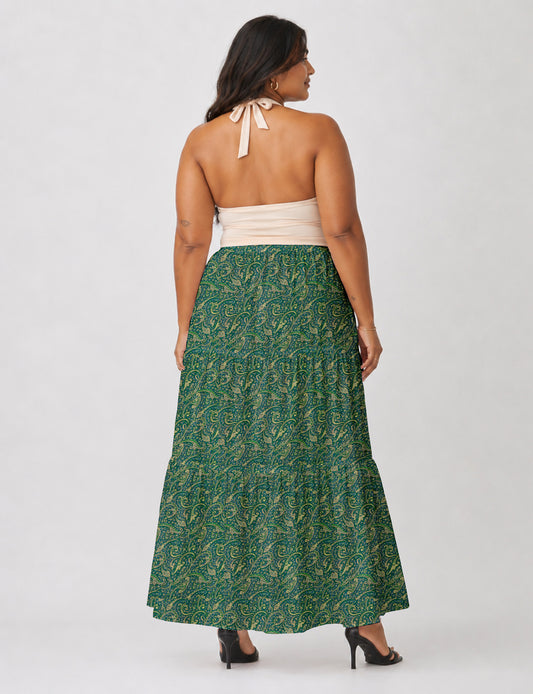 Woman wearing a yellow midi tiered skirt with a small geometric pattern, paired with a beige strapless top and white heels