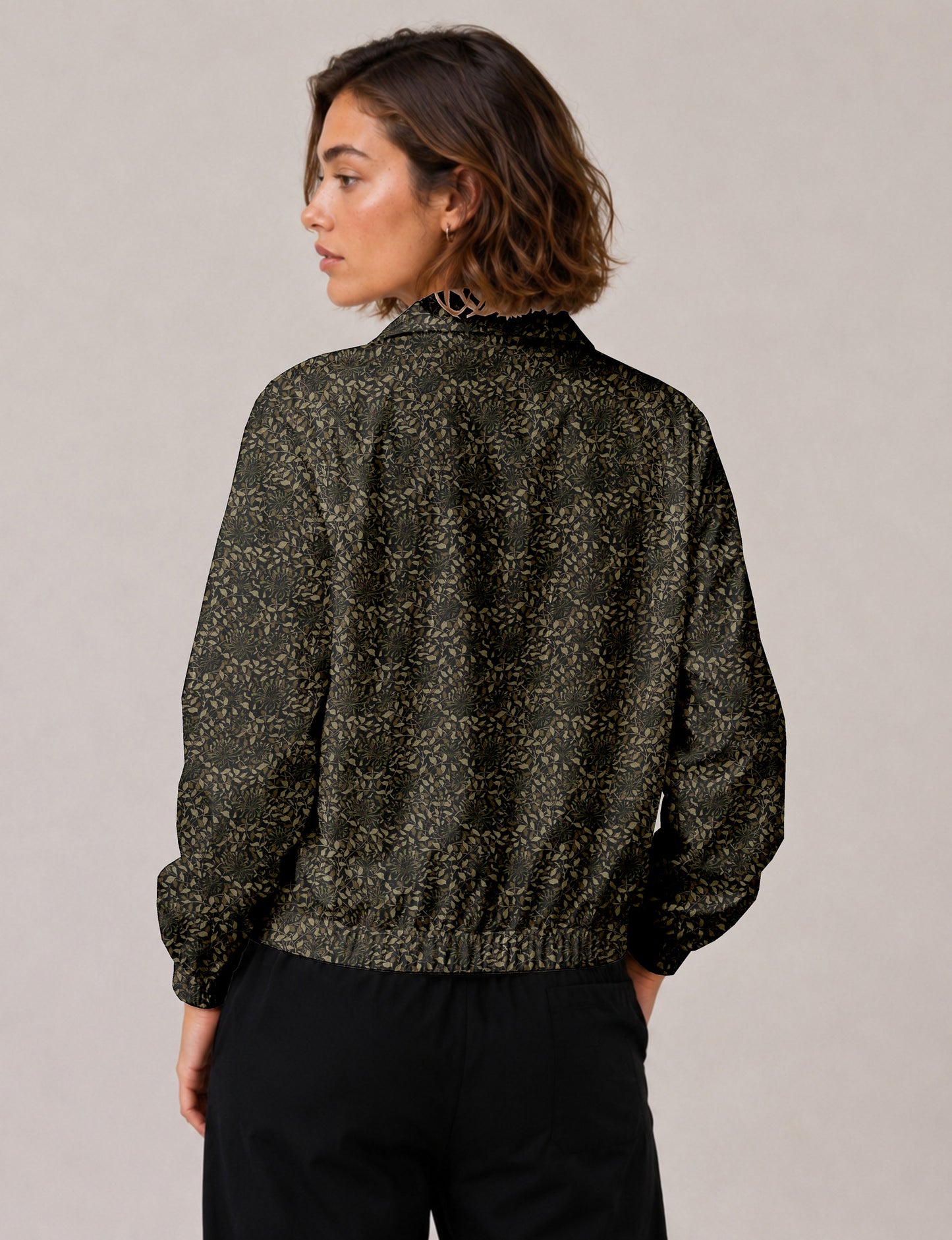 Woman wearing a yellow floral bomber jacket with front zipper, elastic cuffs, and side pockets, shown from front view