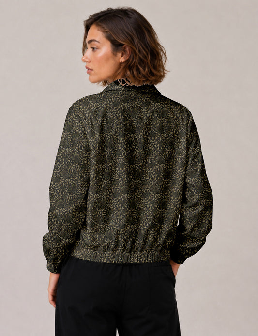Woman wearing a yellow floral bomber jacket with front zipper, elastic cuffs, and side pockets, shown from front view