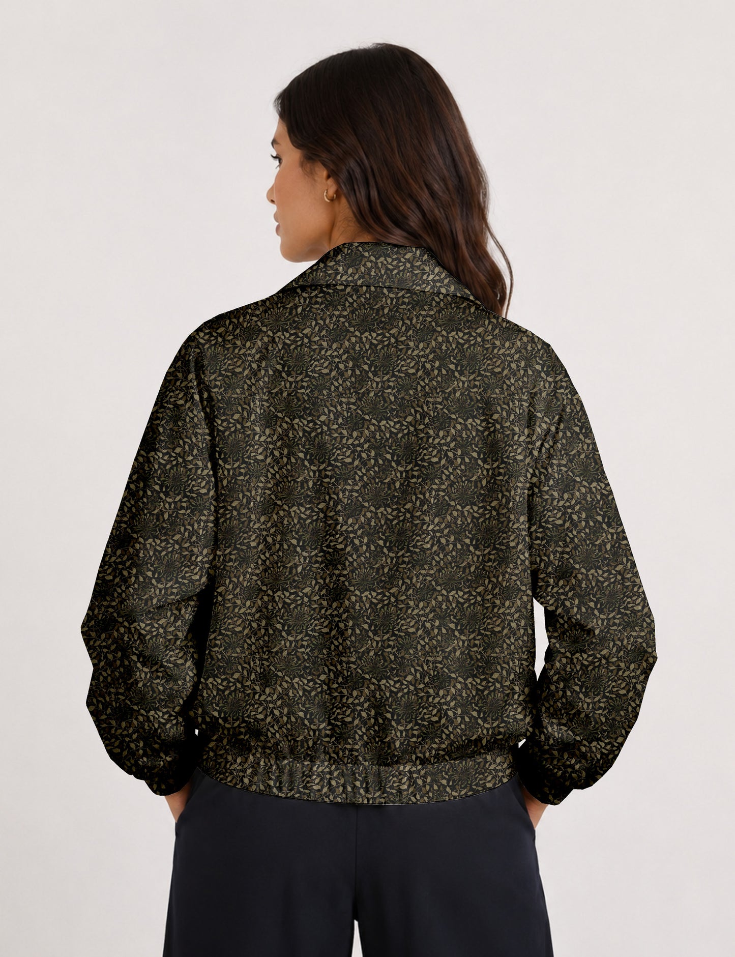 Woman wearing a yellow floral bomber jacket with front zipper, elastic cuffs, and side pockets, shown from front view
