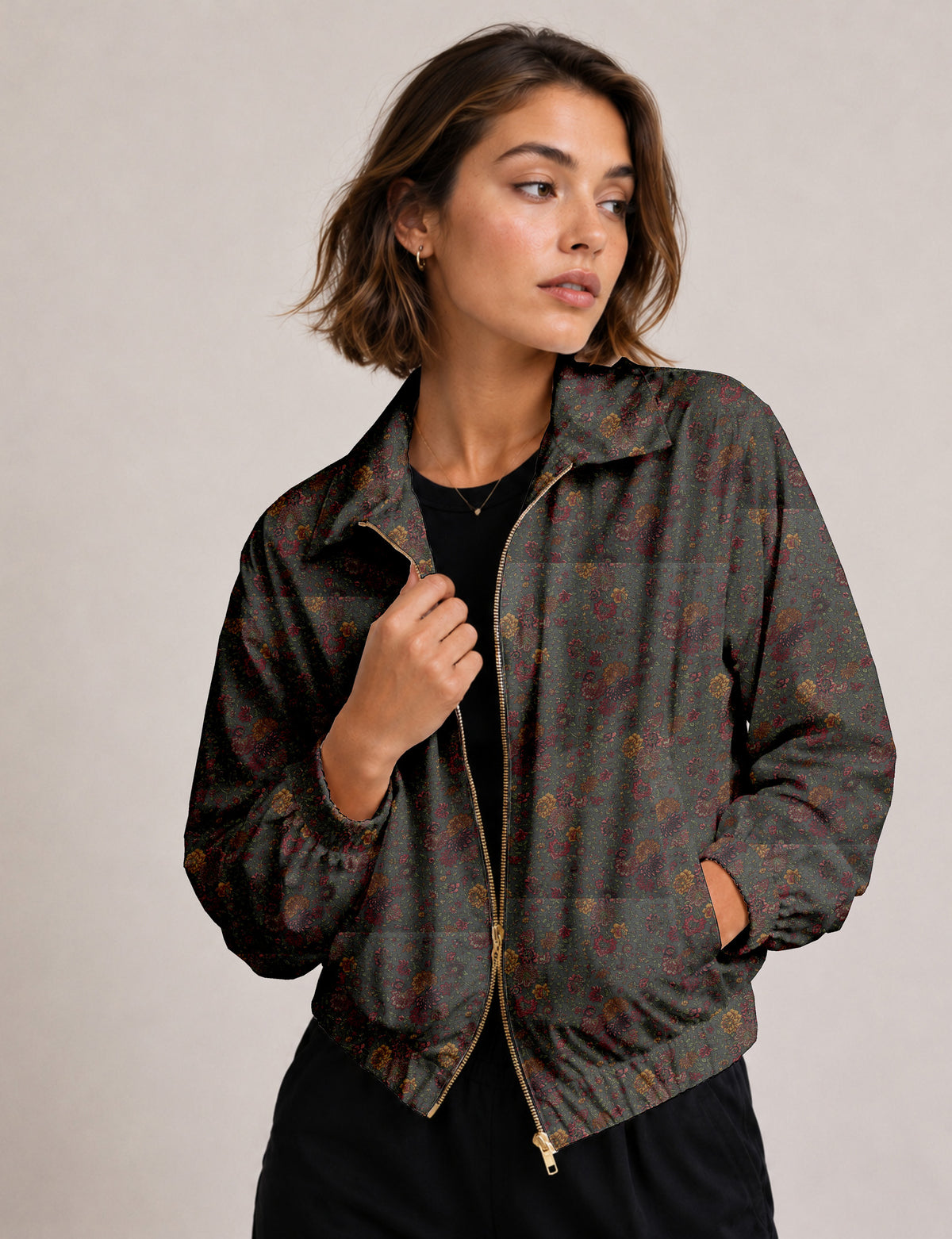 Brown floral bomber jacket with front zipper, elastic cuffs and hem, hanging on white hanger, red floral inner lining visible
