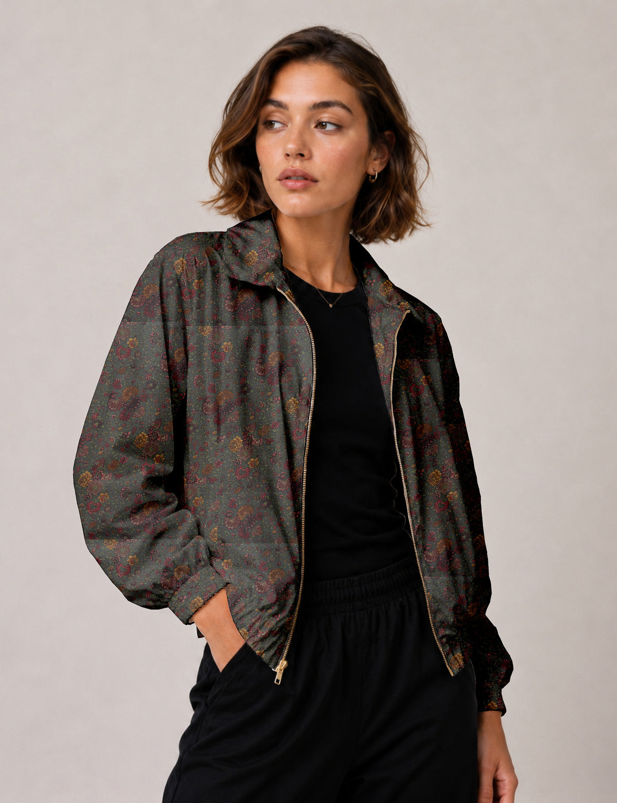 Woman wearing a yellow floral bomber jacket with front zipper, elastic cuffs, and side pockets, shown from front view
