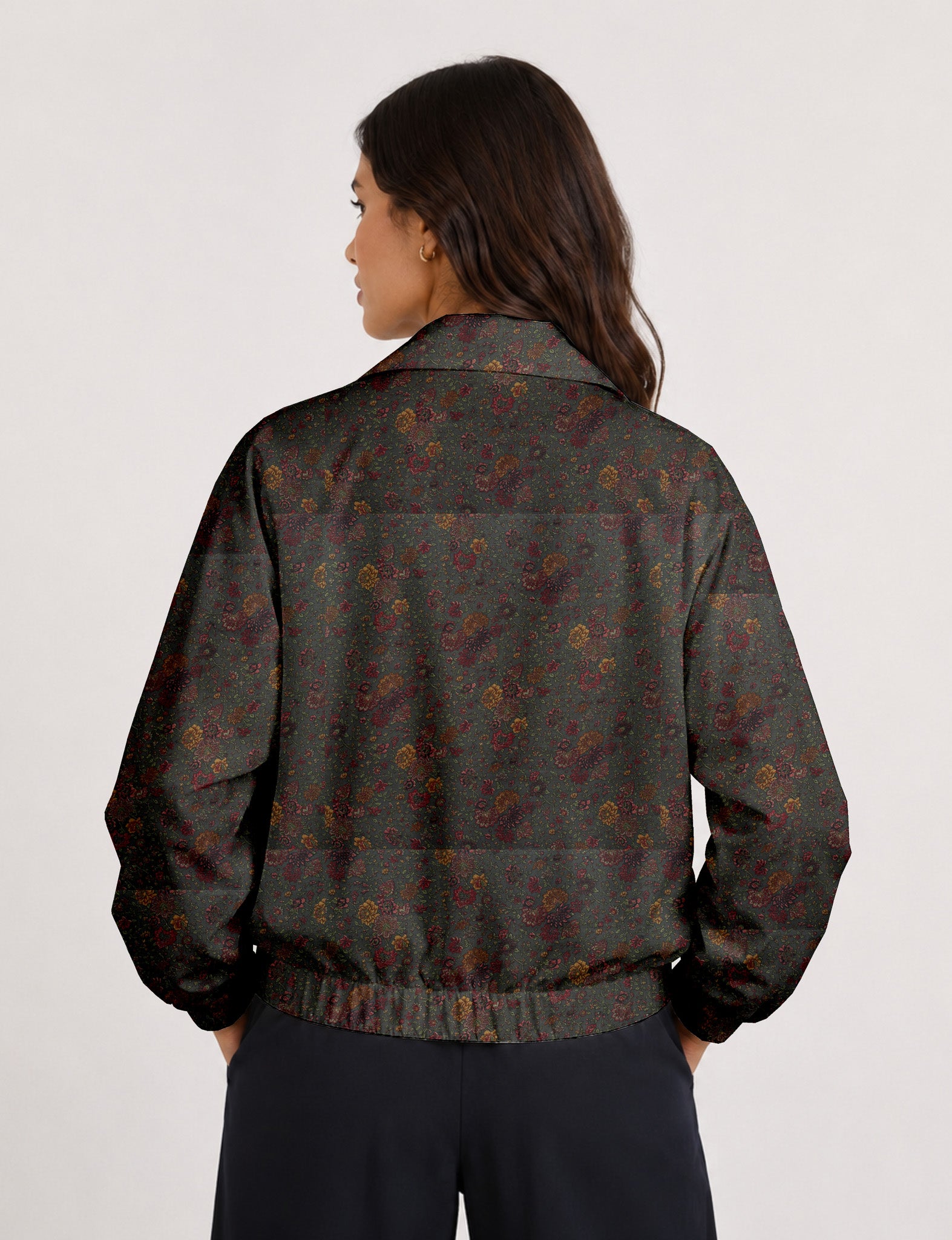 Woman wearing a yellow floral bomber jacket with front zipper, elastic cuffs, and side pockets, shown from front view