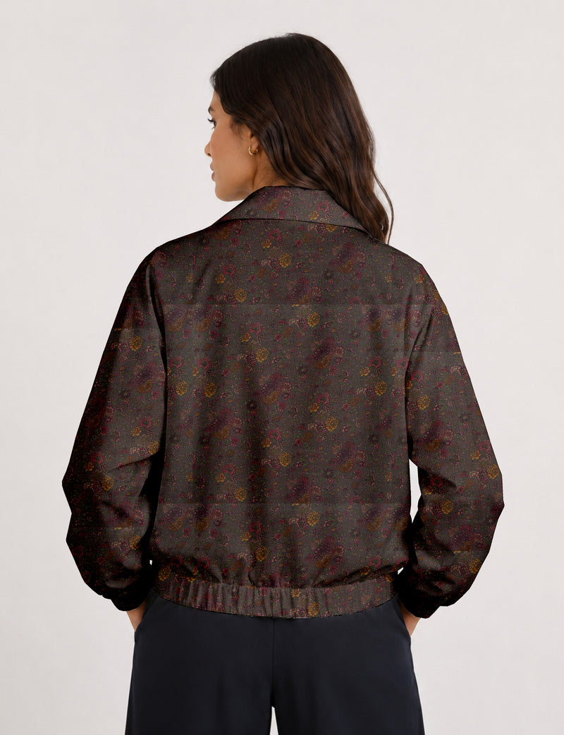 Woman wearing a yellow floral bomber jacket with front zipper, elastic cuffs, and side pockets, shown from front view