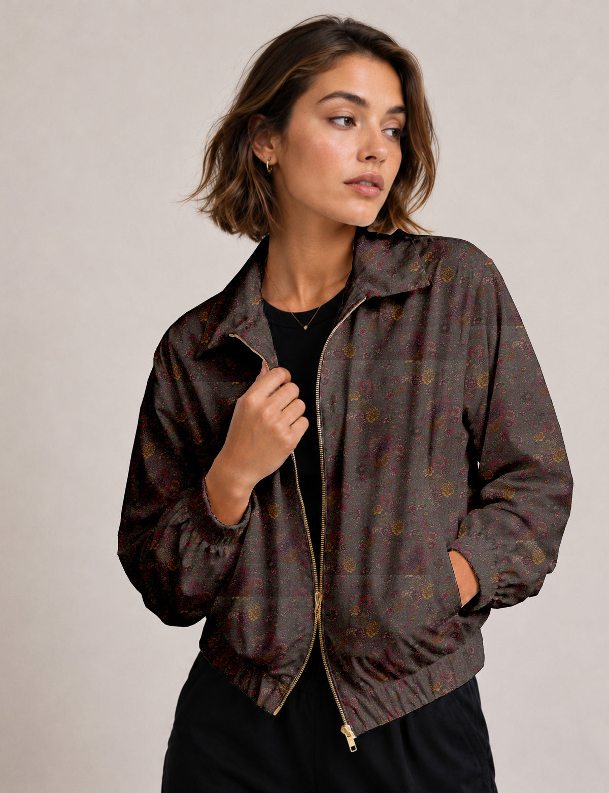 Woman wearing a yellow floral bomber jacket with front zipper, elastic cuffs, and side pockets, shown from front view