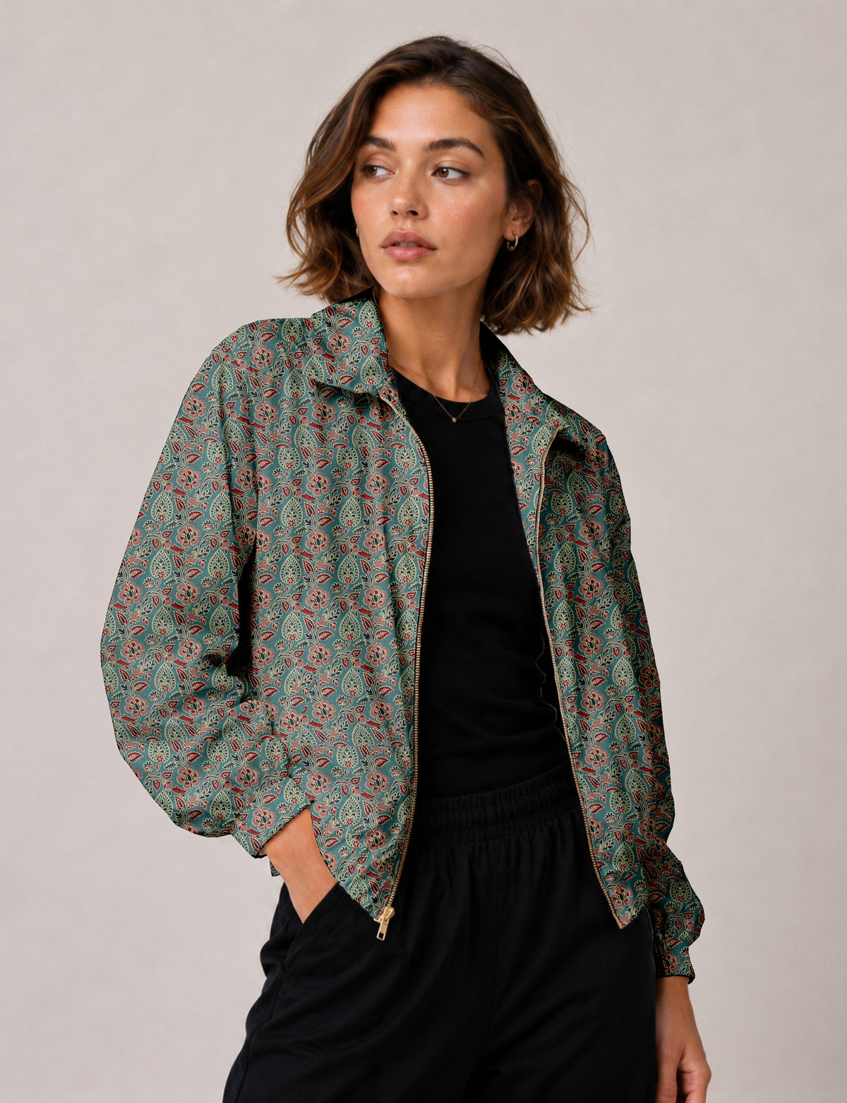 Brown floral bomber jacket with front zipper, elastic cuffs and hem, hanging on white hanger, red floral inner lining visible