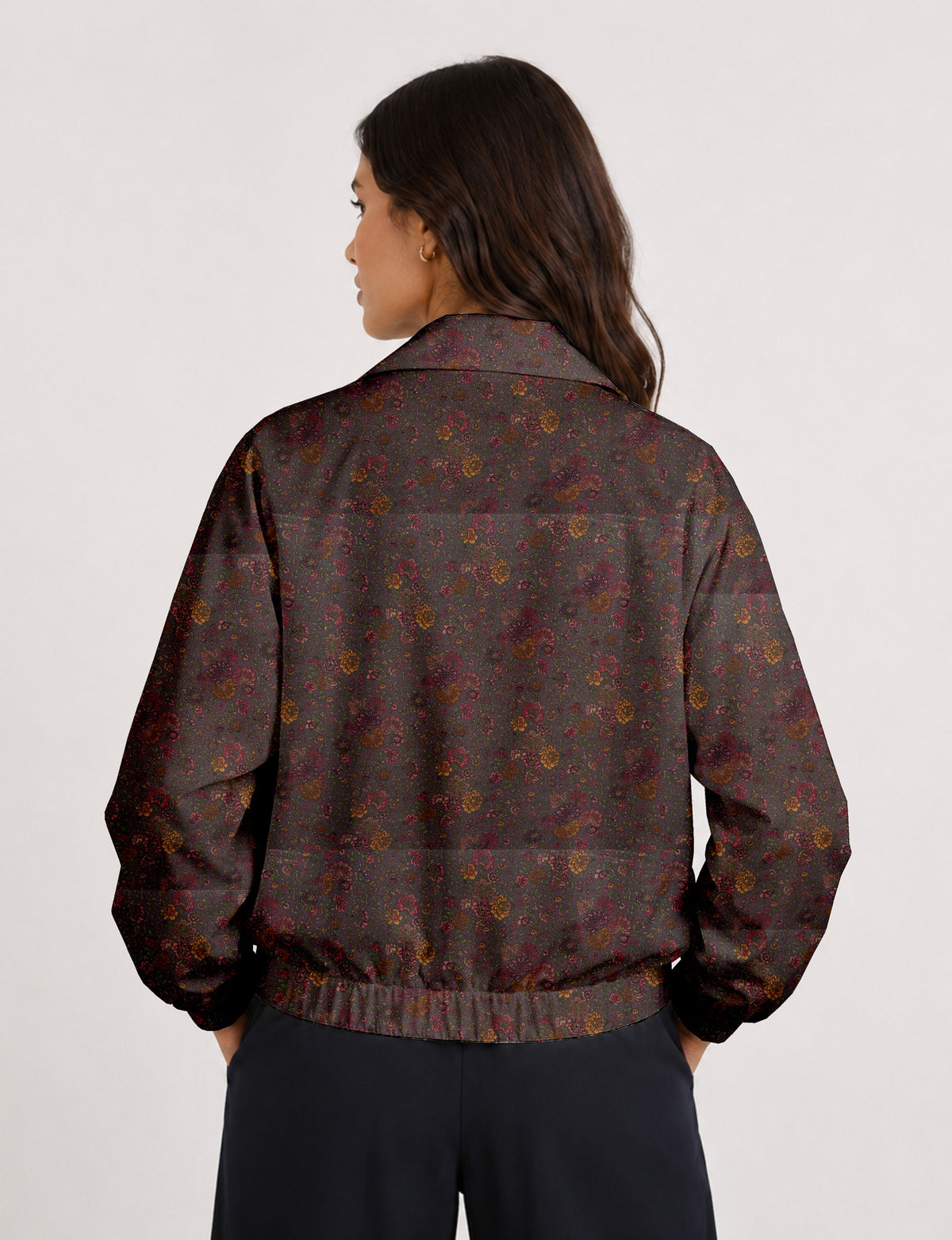 Woman wearing a yellow floral bomber jacket with front zipper, elastic cuffs, and side pockets, shown from front view