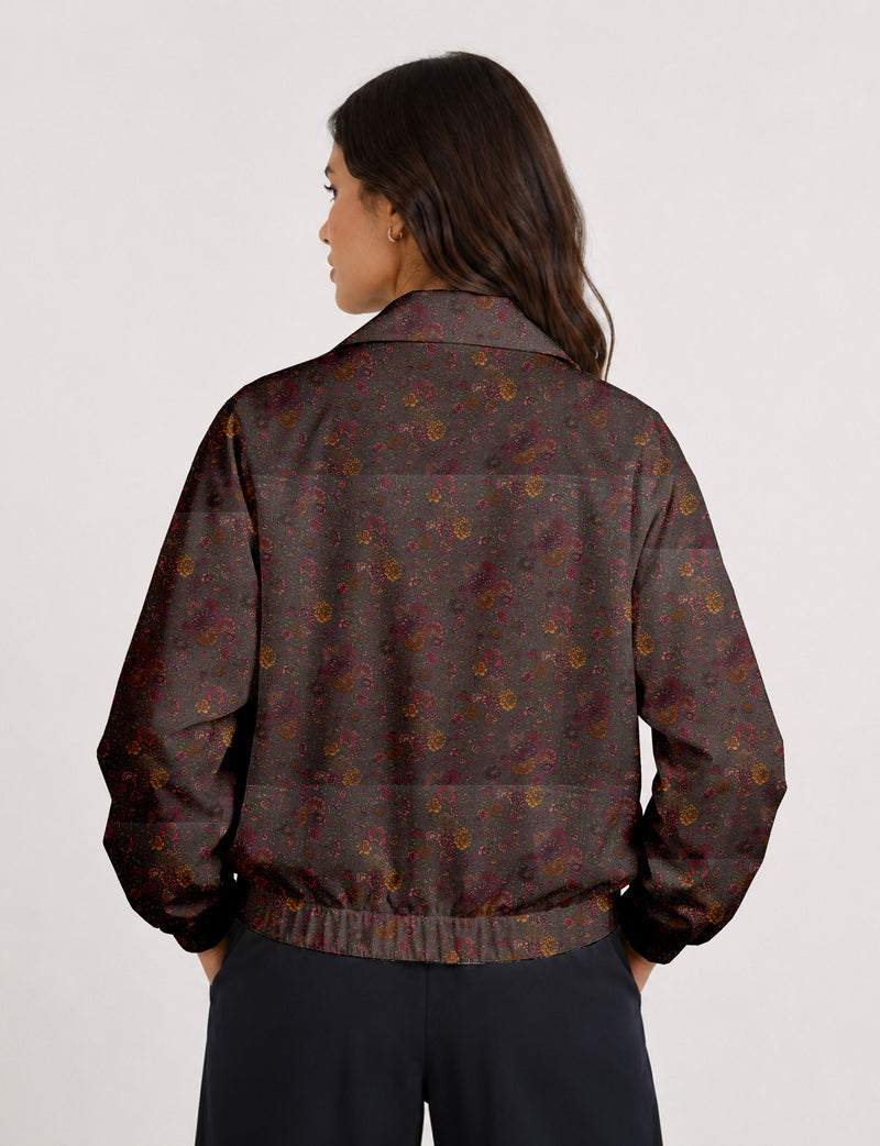 Woman wearing a yellow floral bomber jacket with front zipper, elastic cuffs, and side pockets, shown from front view