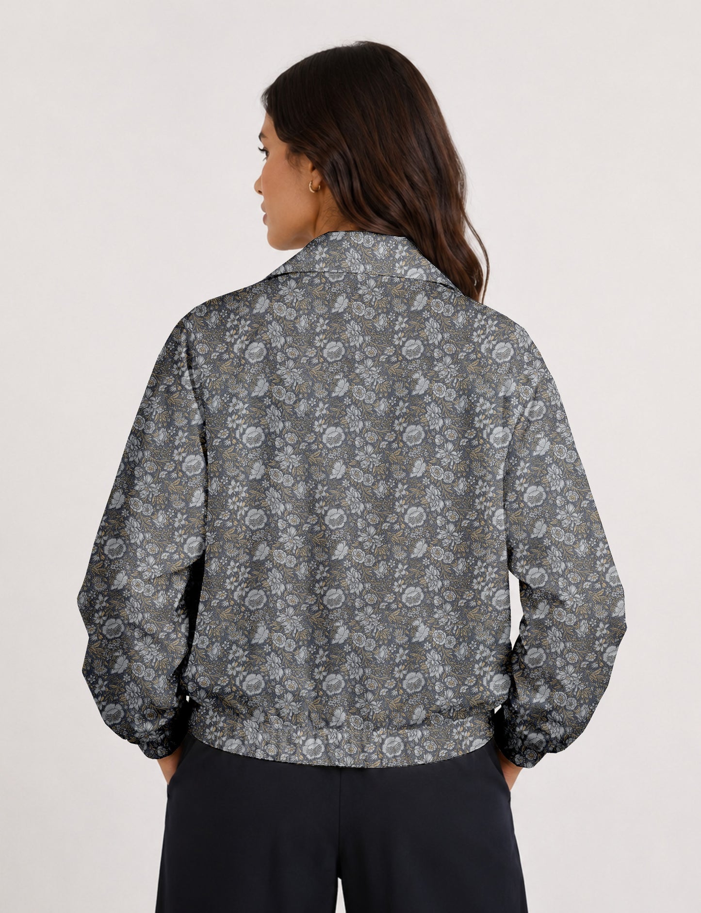 Woman wearing a yellow floral bomber jacket with front zipper, elastic cuffs, and side pockets, shown from front view