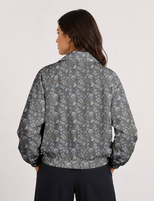 Woman wearing a yellow floral bomber jacket with front zipper, elastic cuffs, and side pockets, shown from front view