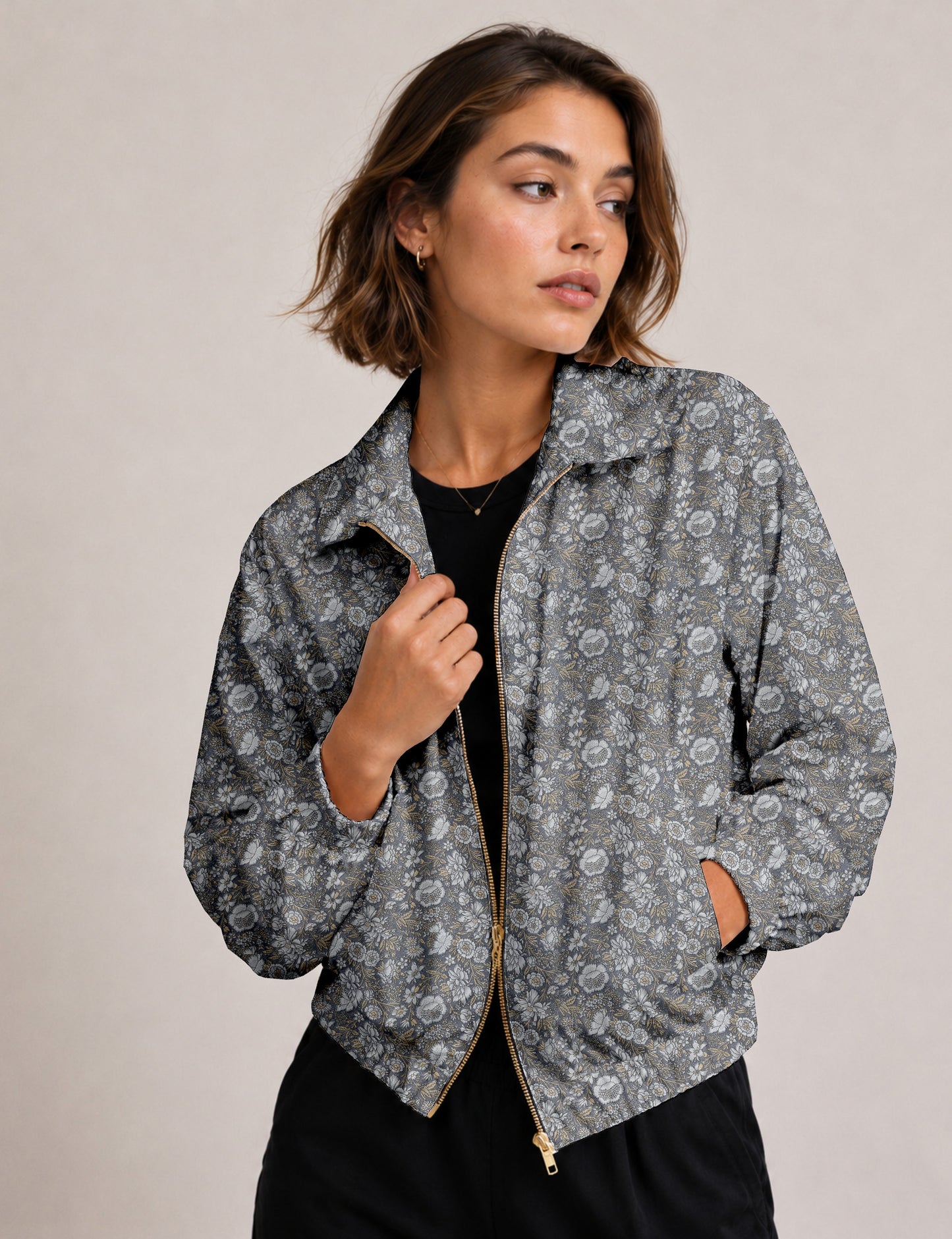 Woman wearing a yellow floral bomber jacket with front zipper, elastic cuffs, and side pockets, shown from front view