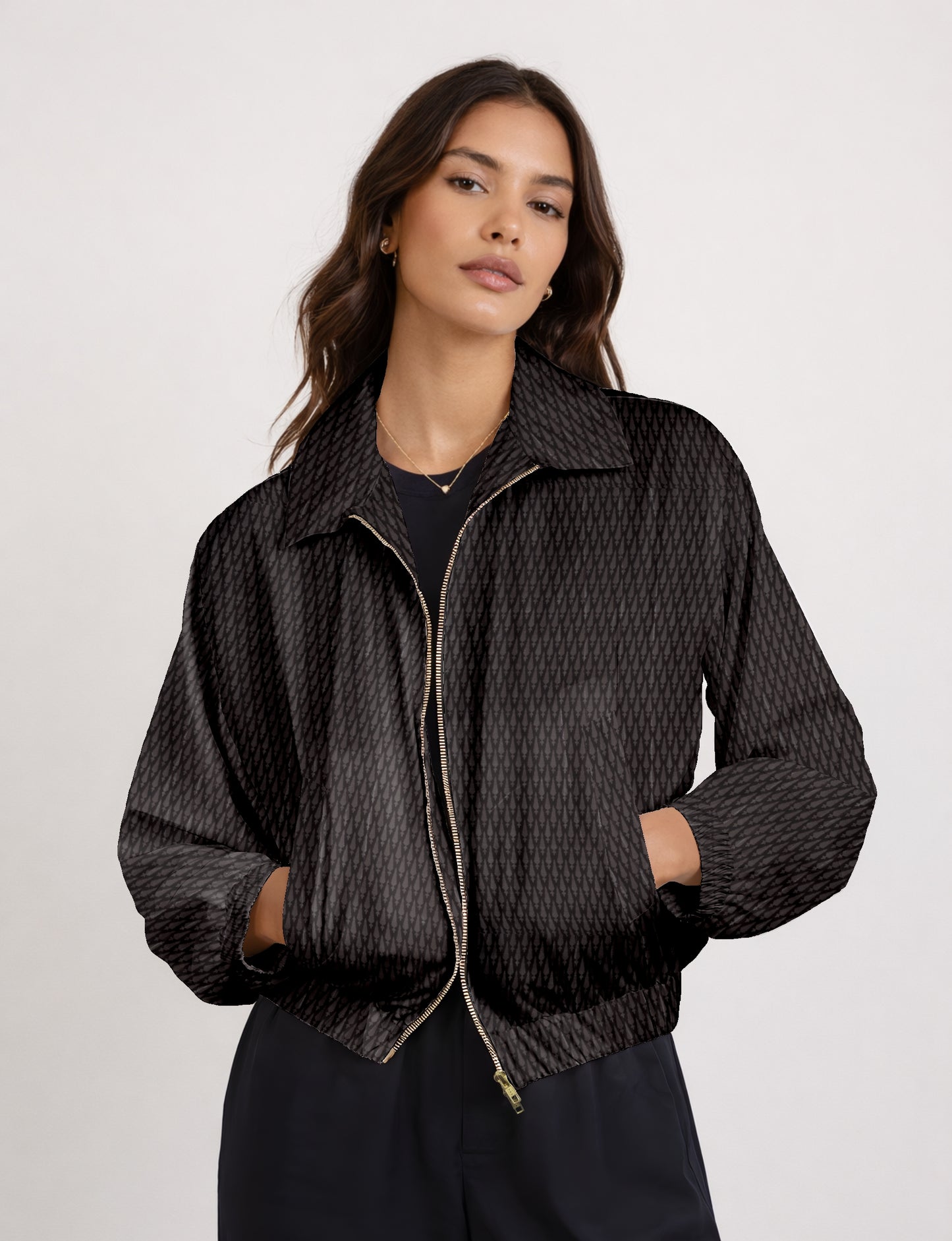 Woman wearing a yellow bomber jacket with a micro geometric pattern, front zipper, and side pockets, paired with black pants