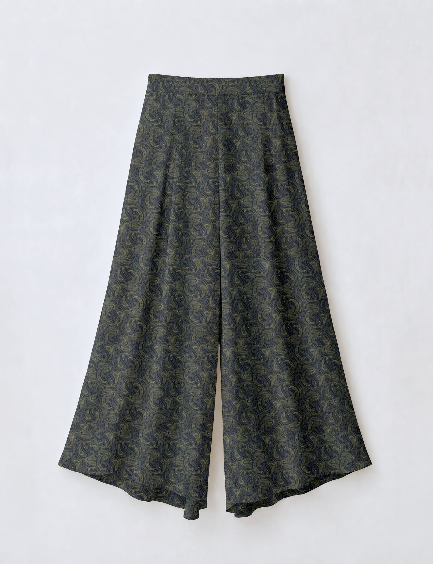 Woman wearing blue wide leg palazzo trousers with black and brown tropical floral print, side pockets, shown from back angle