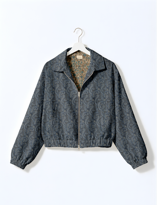 Women's cropped bomber jacket with twin metallic front zippers, welt pockets, elasticated hem and cuffs, and contrast sari print lining.