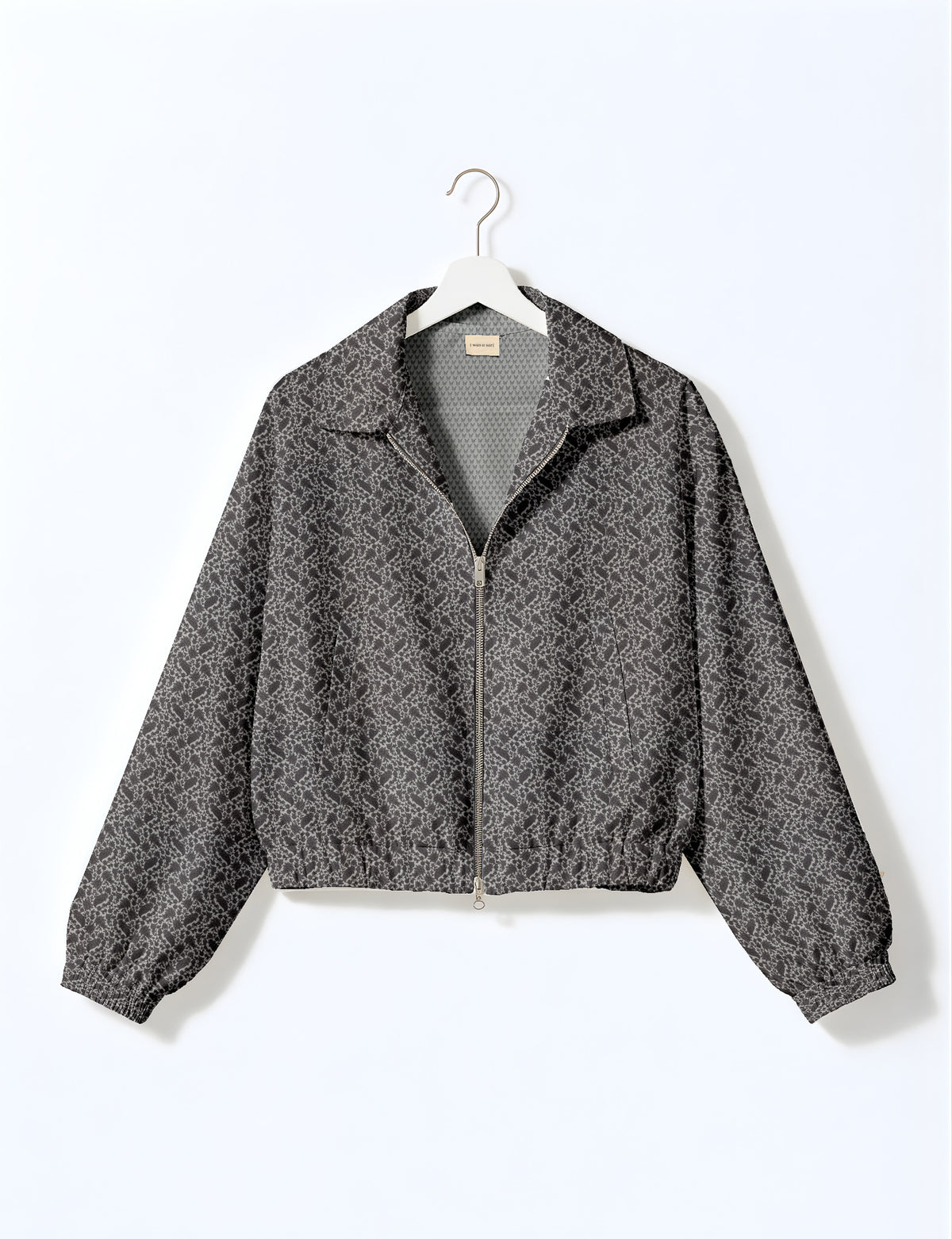 Brown floral bomber jacket with front zipper, elastic cuffs and hem, hanging on white hanger, red floral inner lining visible